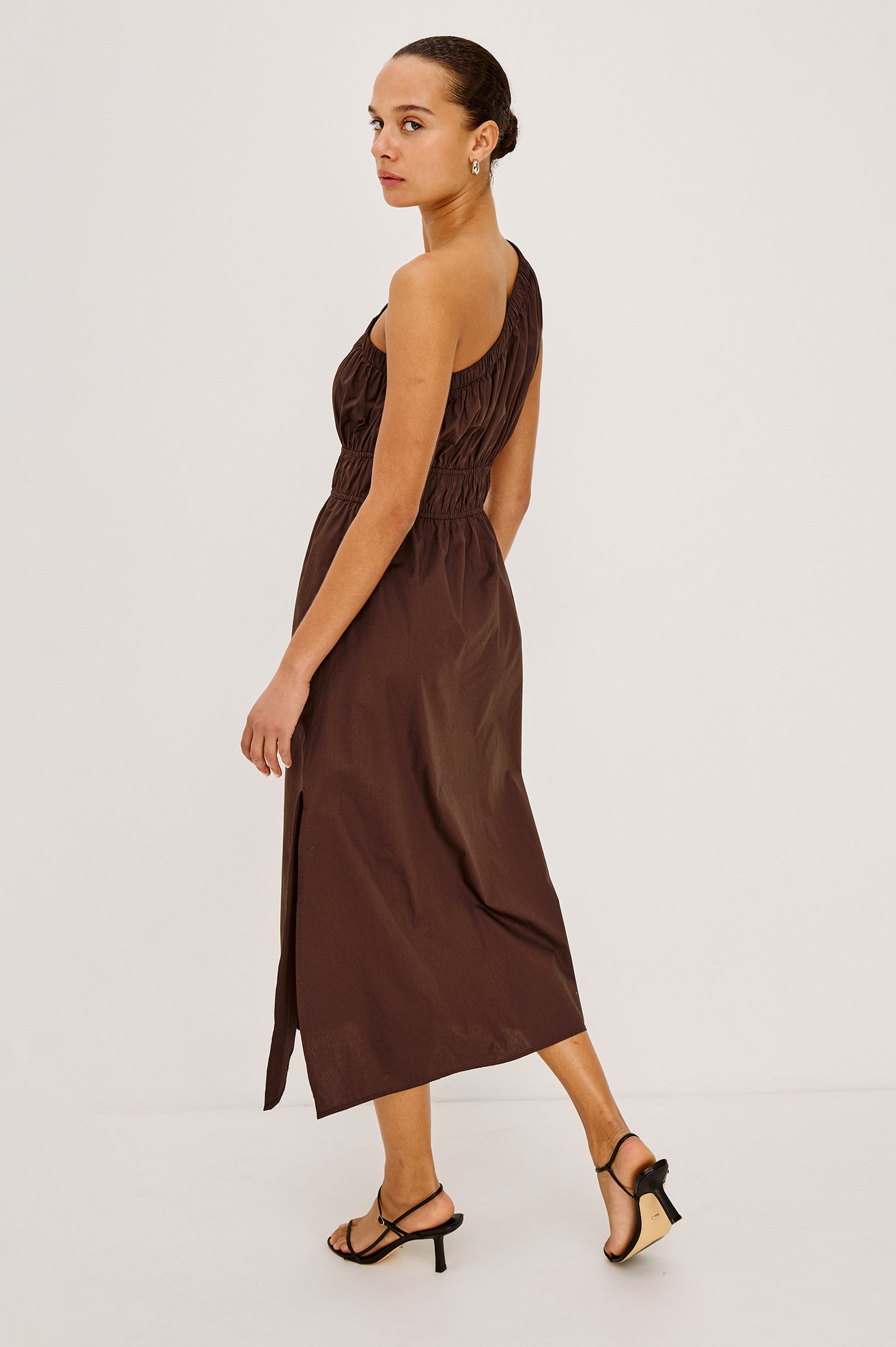 Selani Midi Dress in Cotton Poplin With One-Shoulder Neckline, Shirred Waistband, Concealed Side Pockets, and Side Slit in Espresso Colorway - Full Body Back View Featured on Model