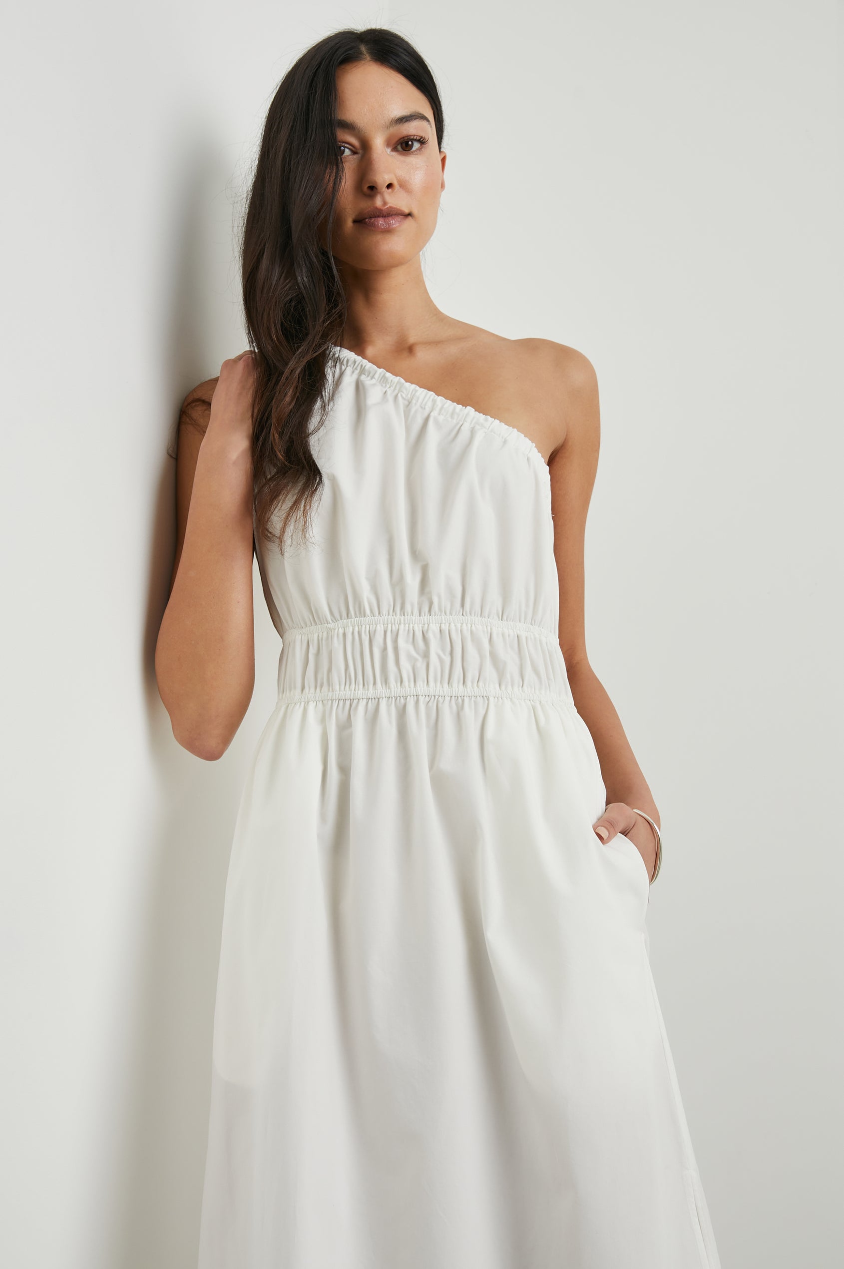 Selani Midi Dress With an Asymmetrical Neckline, Mid-Thigh Slide Slit and Cinched Waistband in White Colorway - Front View Featured on Model