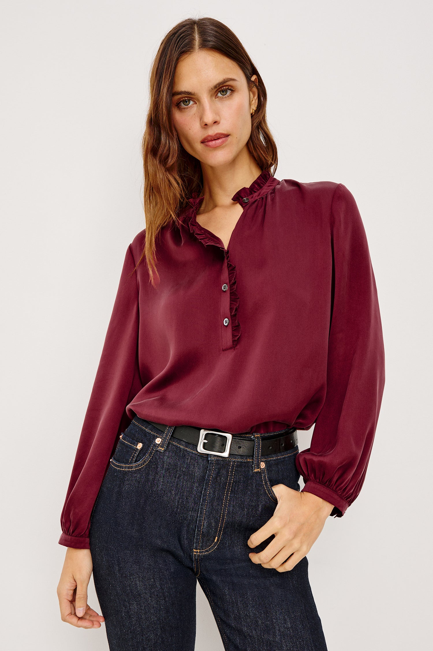 Sien Top in Silk Charmeuse With Ruffled High Neckline, Half Button Placket, and Long Billowing Sleeves With Fitted Cuffs in Garnet Colorway - Upper Body Front View Featured on Model