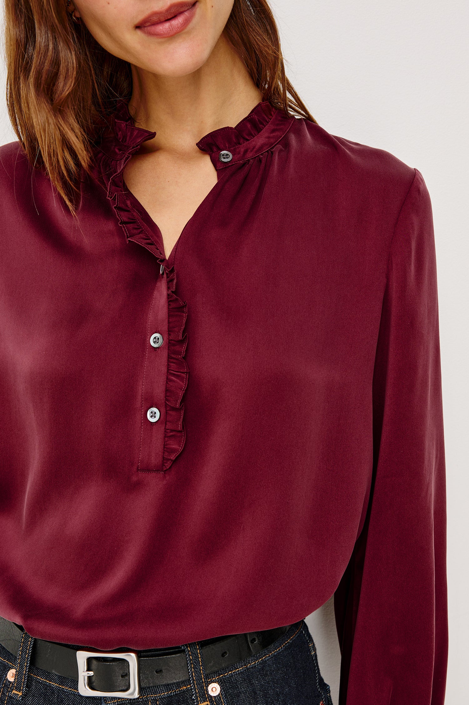 Sien Top in Silk Charmeuse With Ruffled High Neckline, Half Button Placket, and Long Billowing Sleeves With Fitted Cuffs in Garnet Colorway - Upper Body Close Up Front View Featured on Model