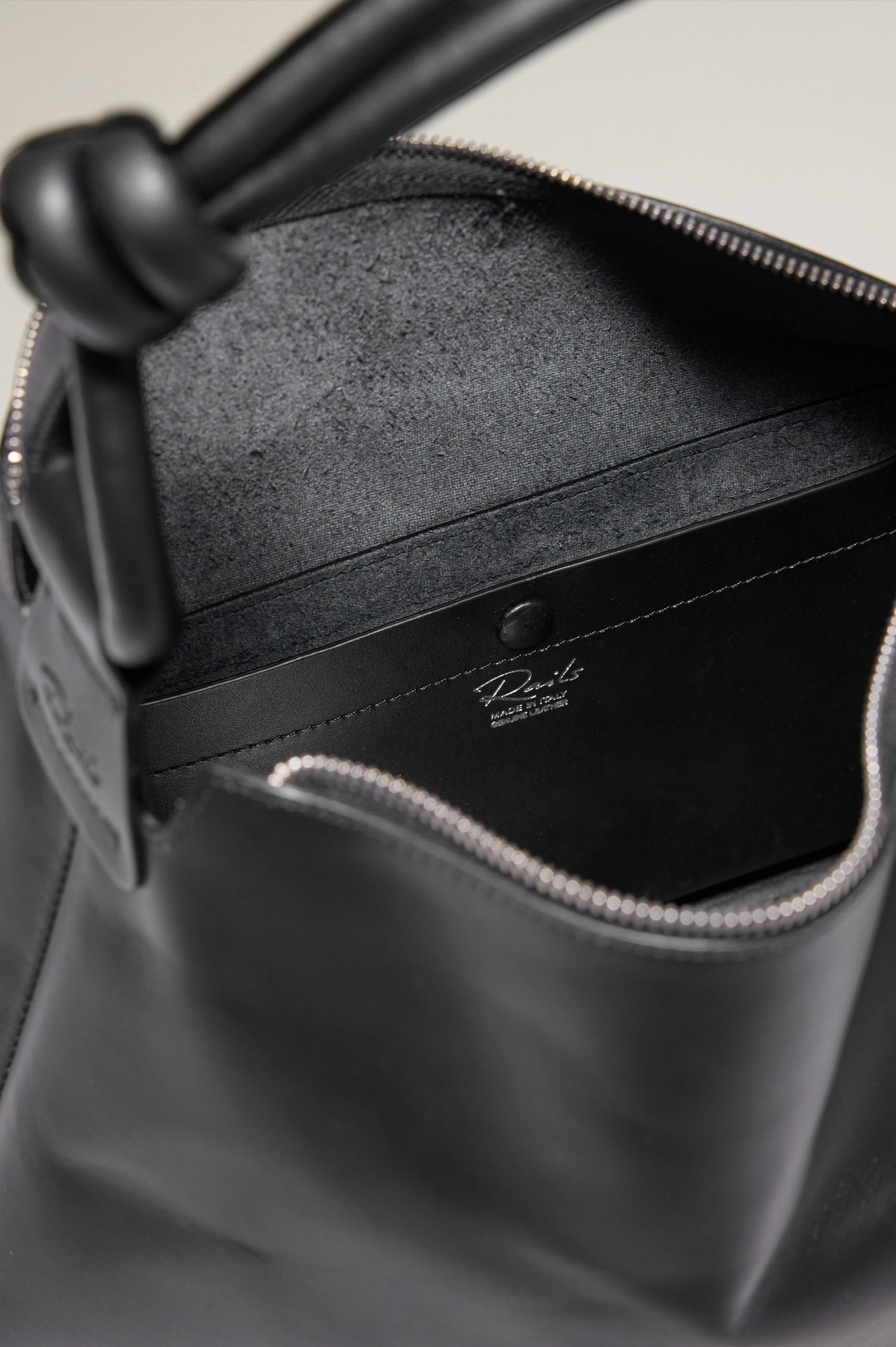 The Siena is a true slouchy hobo bag, crafted from smooth leather with a knotted top strap and a zip closure finished with a fringed tassel. In Black Leather Colorway. Detailed view of interior featured.