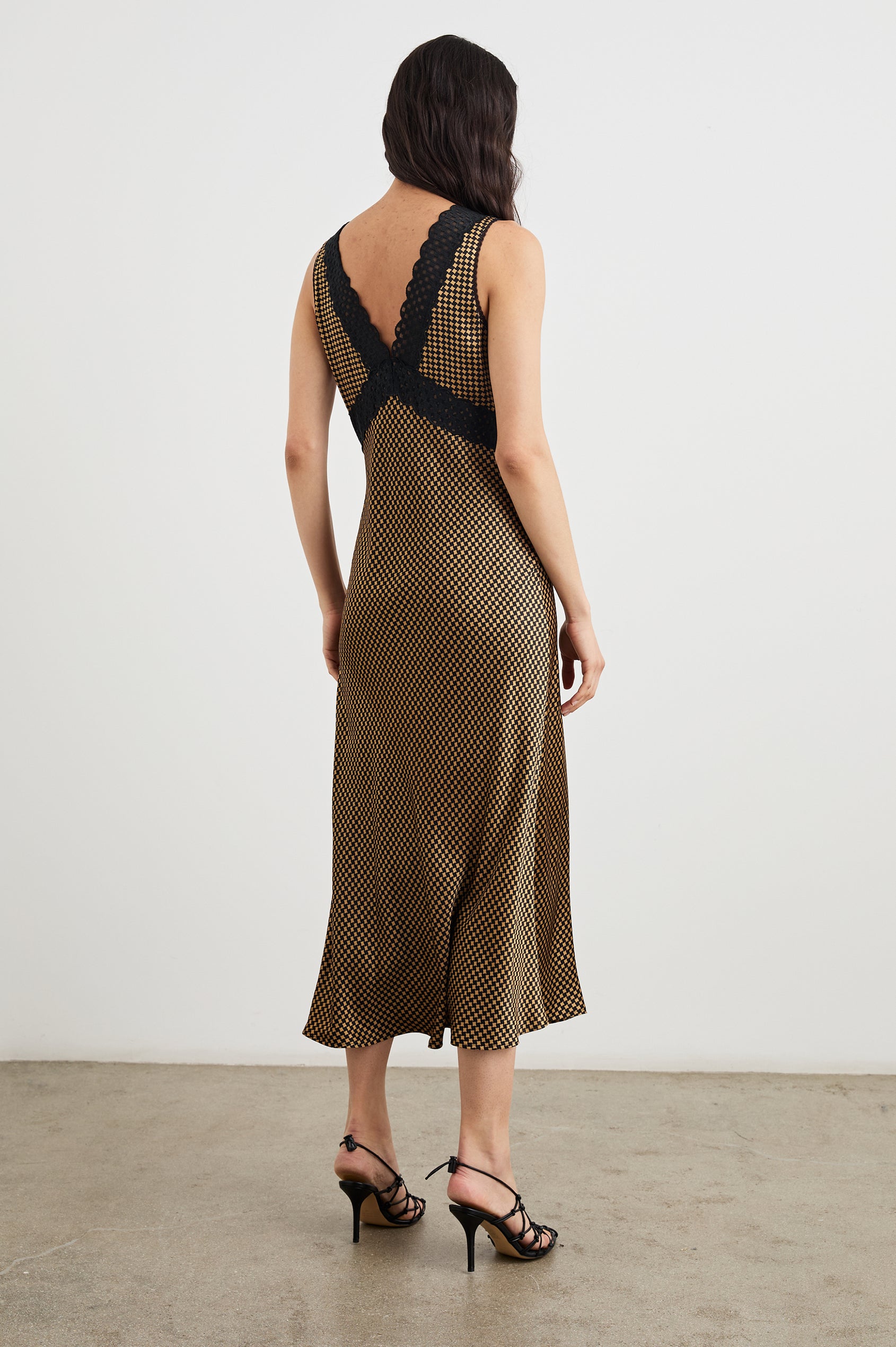 Simona Sleeveless Midi Dress with a Deep V Neck and Black Lace Crossover Trim on the Bodice in Gold Houndstooth Colorway - Back Full Body View Featured on Model