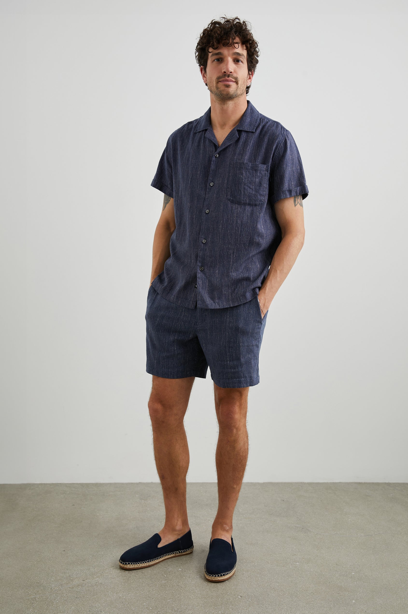 Sona Shorts with Two Front Pockets and Two Back Button Welt Pockets in Matrix Navy Pearl Colorway, Thin Pearl Dashed Vertical Lines on Navy - Front Full Body View Featured on Model 