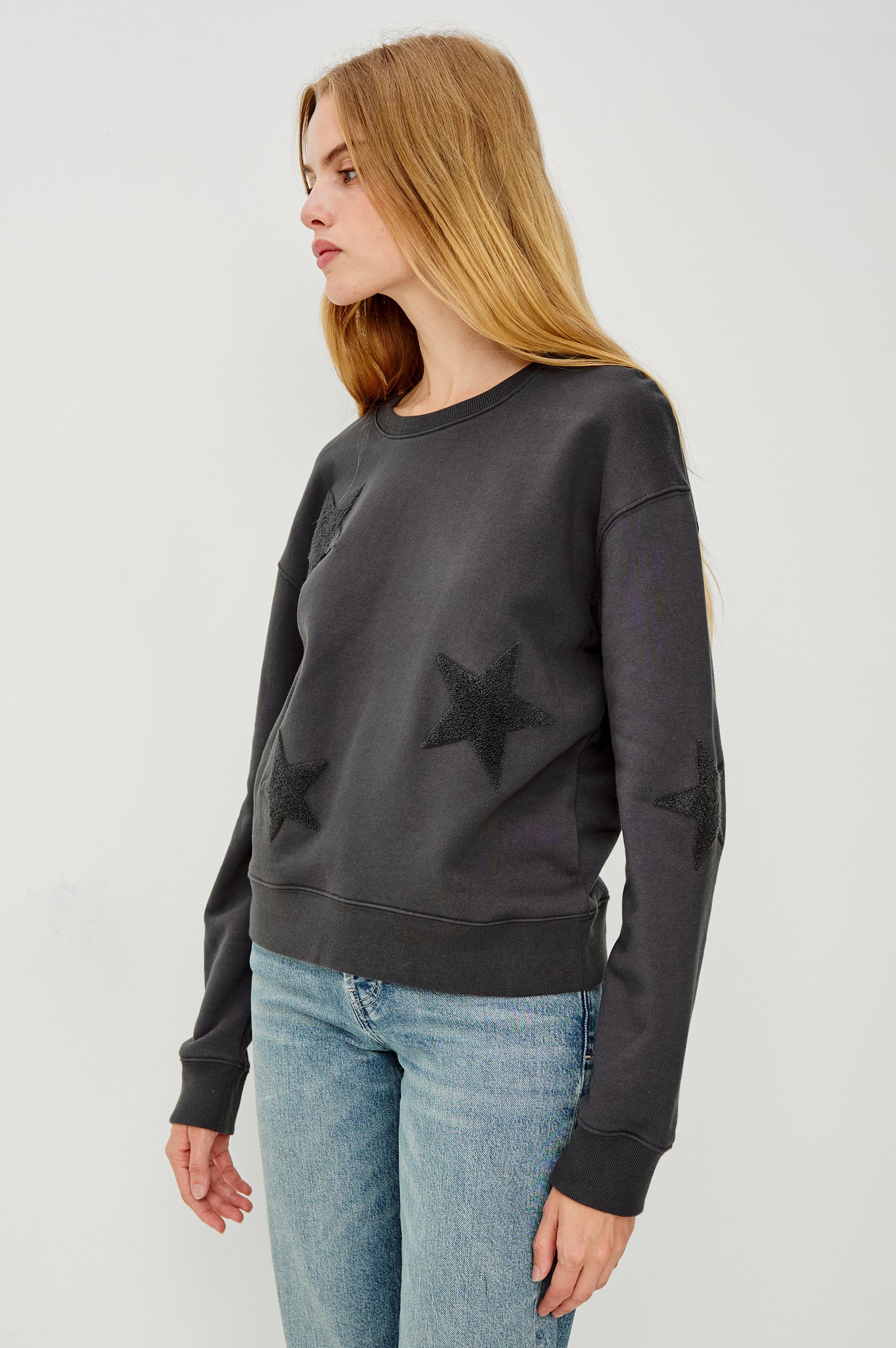 Sonia Long-Sleeve Sweatshirt with a Crew Neck and Charcoal Patch Stars in Washed Black Colorway - Side View Featured on Model