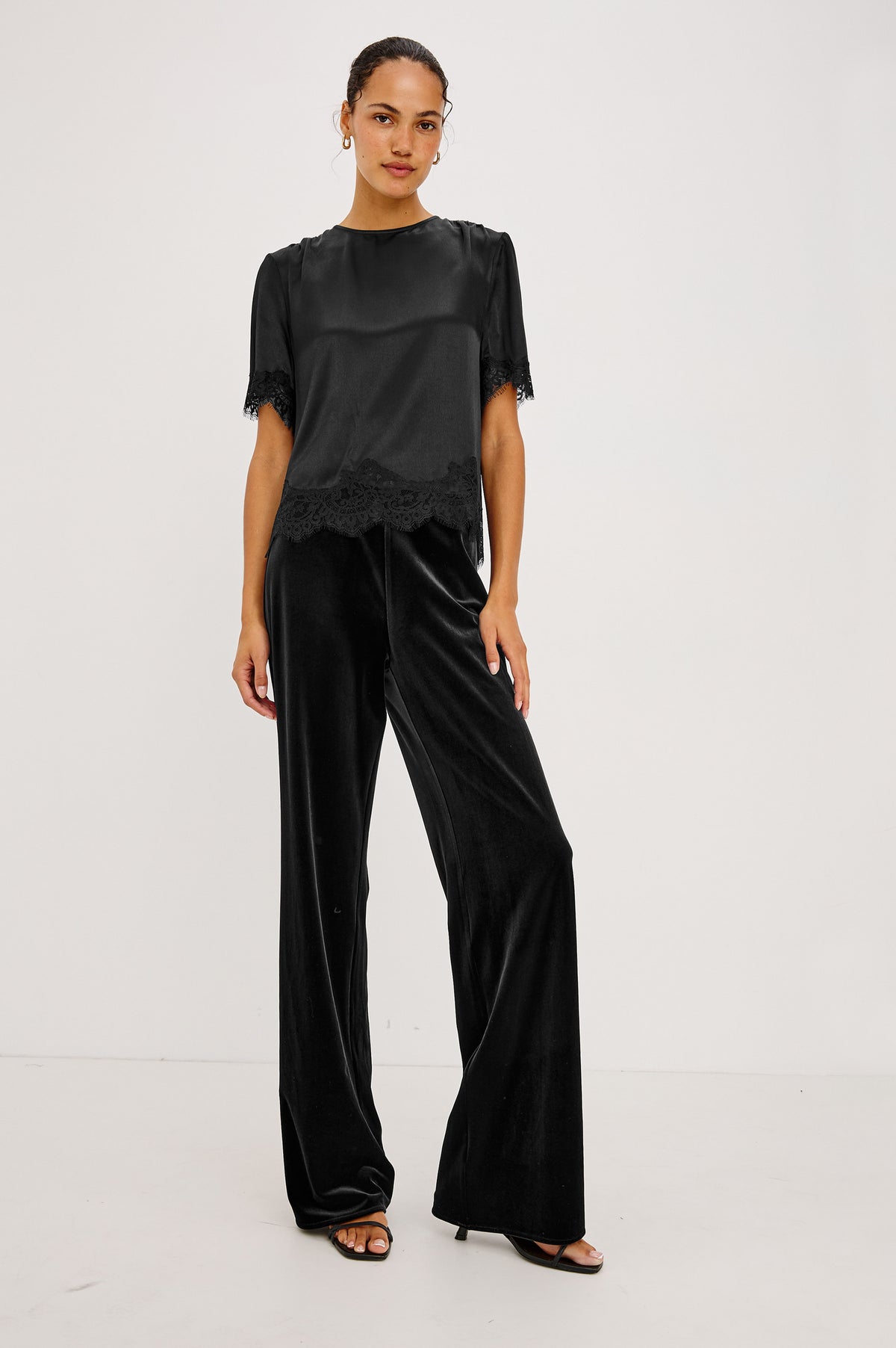 Sonora Shirt in Satin Crepe With Crew Neckline, Loose Boxy Fit, Shirred Shoulders, Short Sleeves, Button-Loop Back Keyhole, and Lace Trim in Black Colorway - Full Body Front View Featured on Model