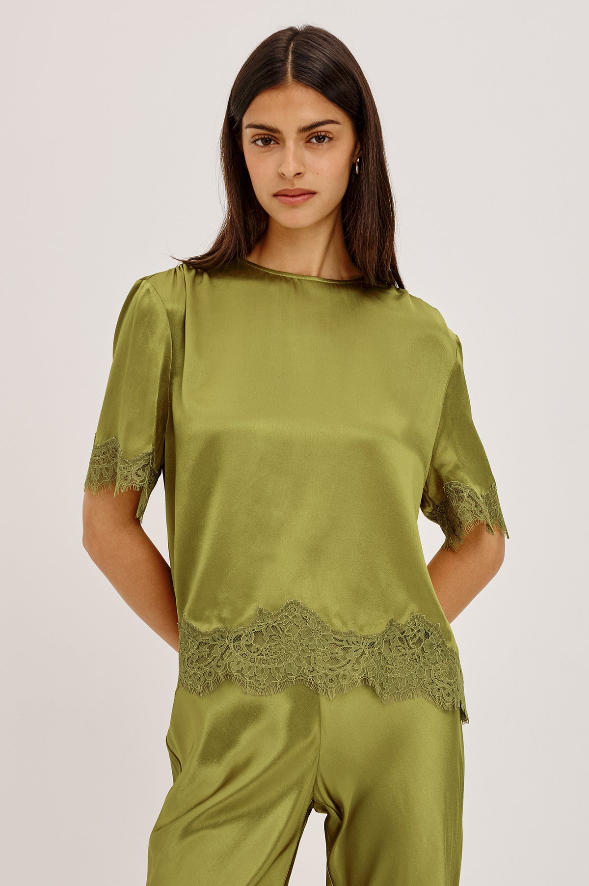 Sonora Shirt in Satin Blend With Loose Boxy Fit, Crew Neck, Shirred Shoulders, Short Sleeves, Button-Loop Back Keyhole, and Lace Trim in Celery ColorwayUpper Body Front View Featured on Model.