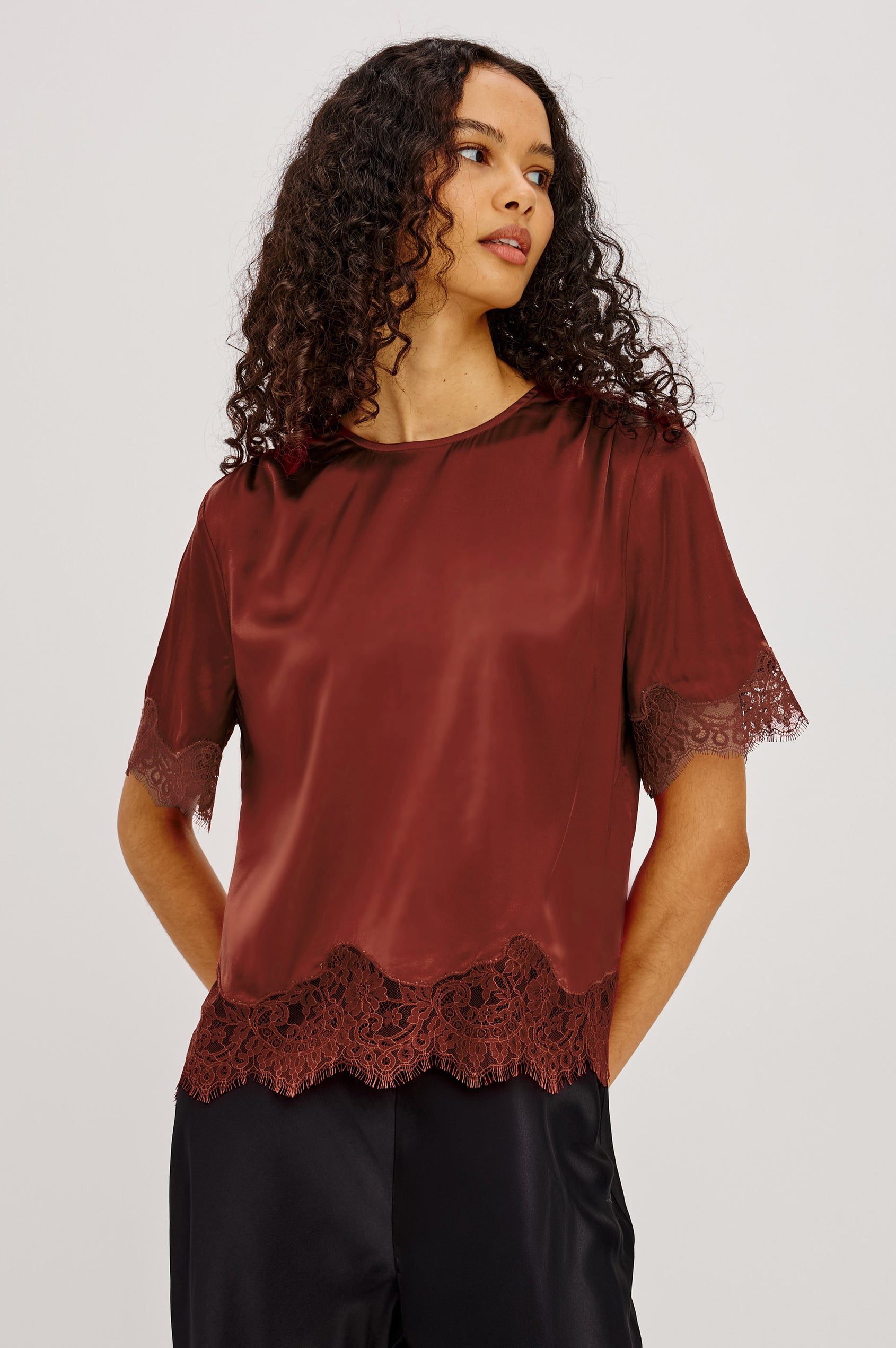 Sonora Shirt in Satin Blend With Loose Boxy Fit, Crew Neck, Shirred Shoulders, Short Sleeves, Button-Loop Back Keyhole, and Lace Trim in Crimson Colorway - Upper Body Front View Featured on Model