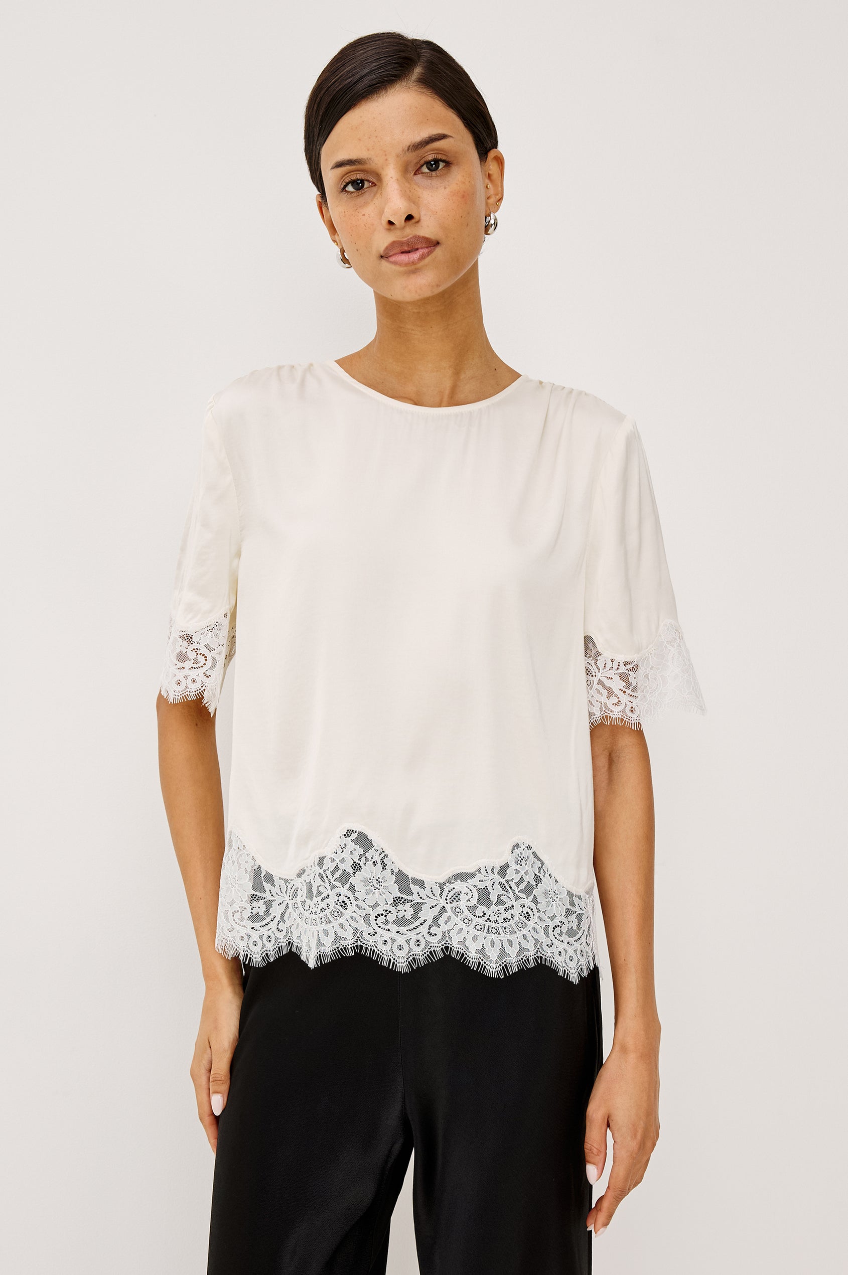 Sonora Shirt in Satin Blend With Loose Boxy Fit, Crew Neck, Shirred Shoulders, Short Sleeves, Button-Loop Back Keyhole, and Lace Trim in Ivory Colorway - Upper Body Front View Featured on Model
