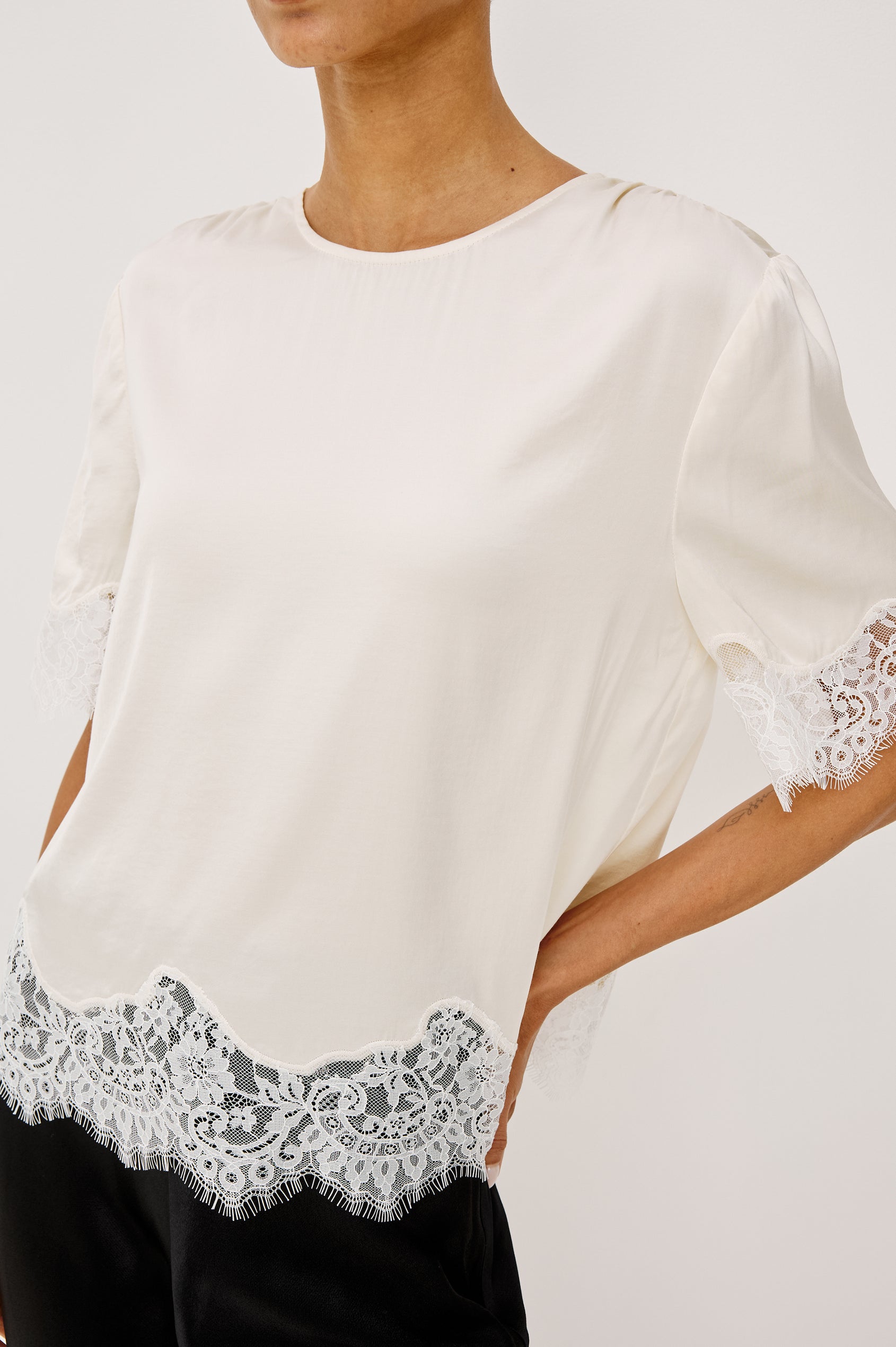 Sonora Shirt in Satin Blend With Loose Boxy Fit, Crew Neck, Shirred Shoulders, Short Sleeves, Button-Loop Back Keyhole, and Lace Trim in Ivory Colorway - Upper Body Front View Featured on Model