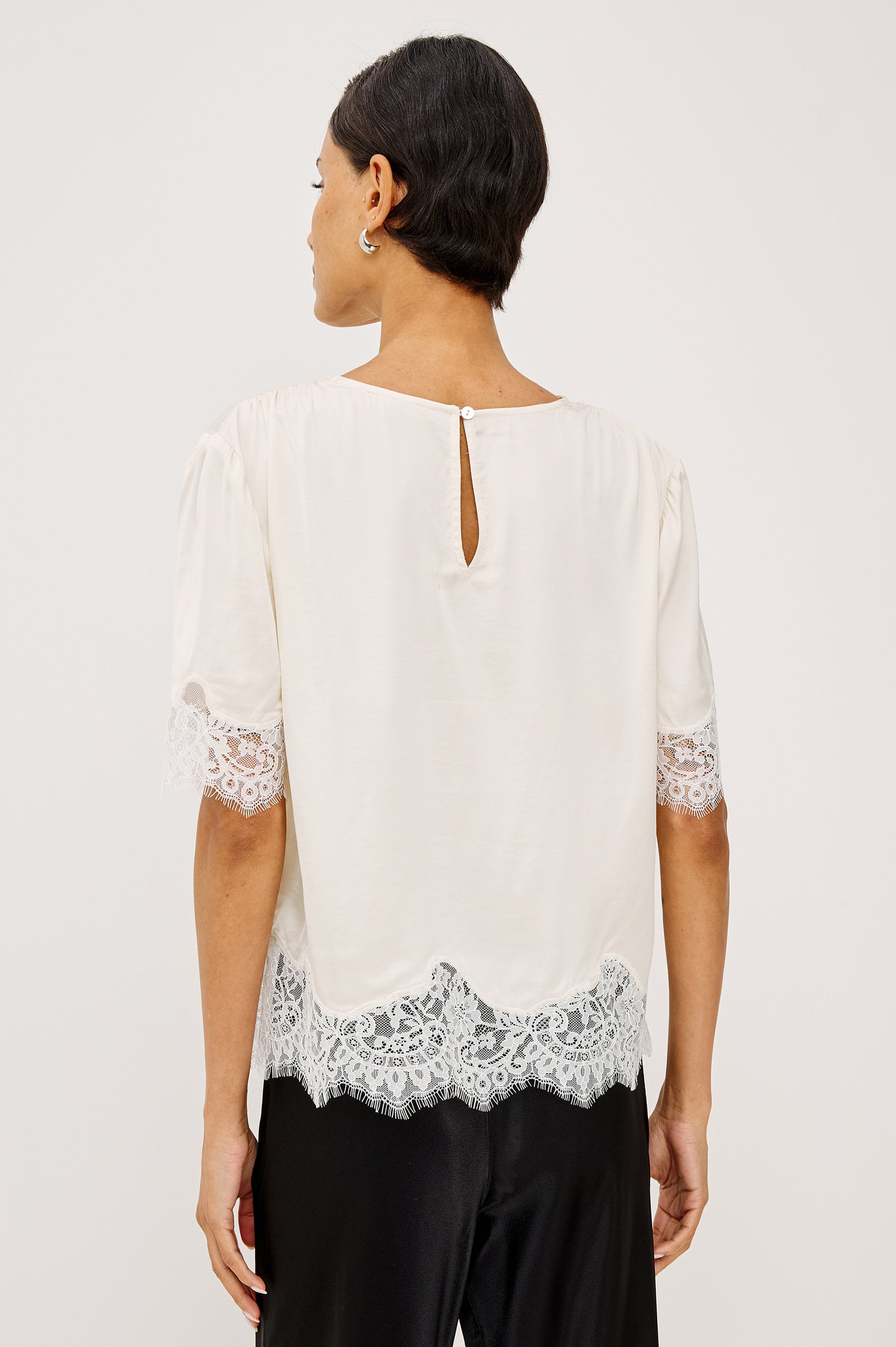 Sonora Shirt in Satin Blend With Loose Boxy Fit, Crew Neck, Shirred Shoulders, Short Sleeves, Button-Loop Back Keyhole, and Lace Trim in Ivory Colorway - Upper Body Back View Featured on Model