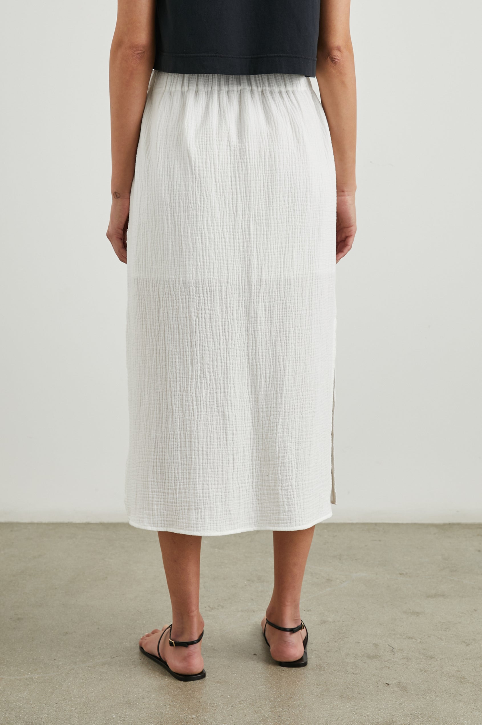 Soraya Midi Skirt with a Side Slit and Lined to the Mid-Thigh in White Colorway - Back View Featured on Model 