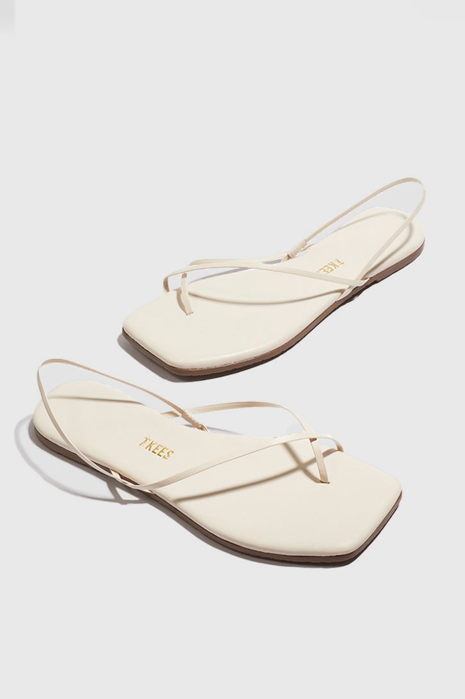 Millie Square toe leather sandal with thin straps wrapping the ankle and front in Cream white - cross angled view of pair of shoes