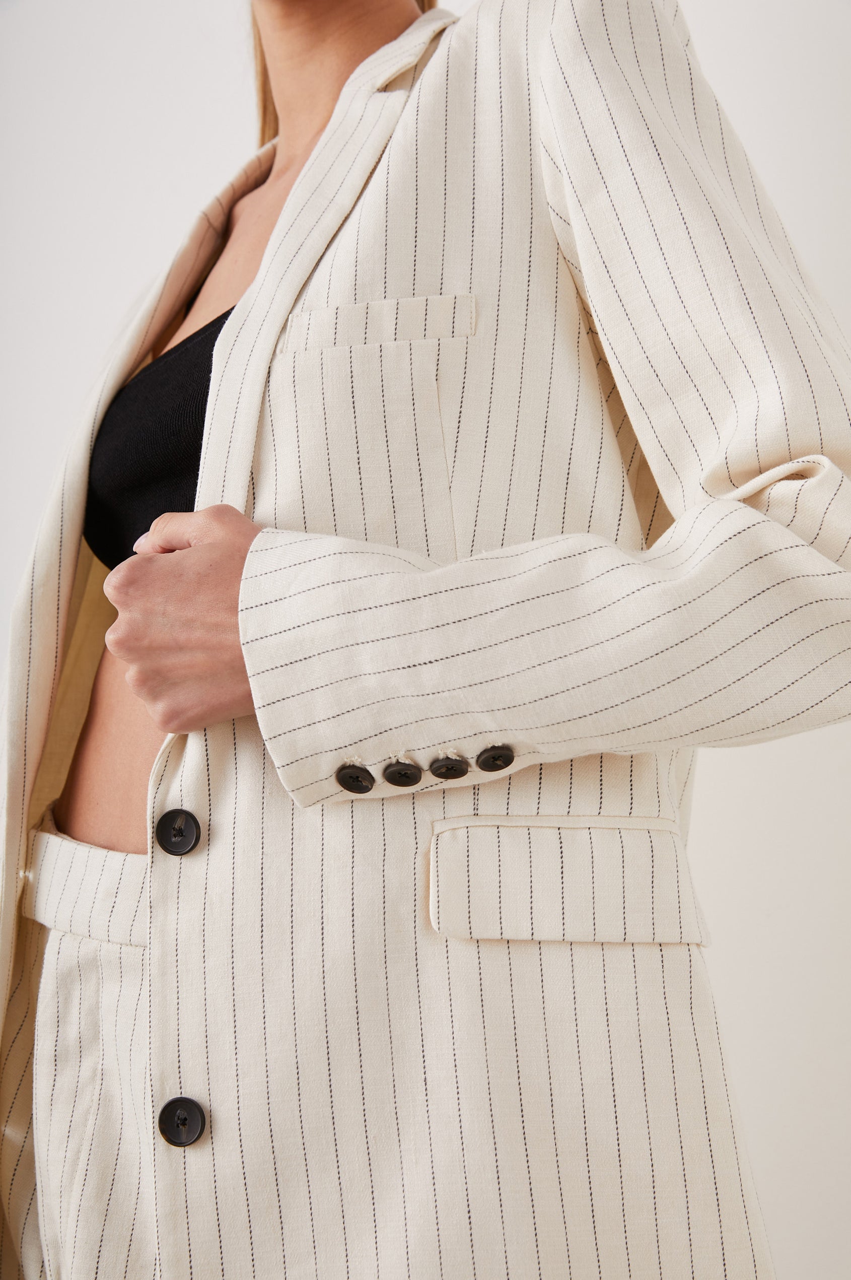 Stanton Blazer with Two Button Closure, Two Front Flap Pockets, a Chest Patch Pocket and Four-Button Cuffs in Ivory Pinstripe Colorway - Side View Featured on Model