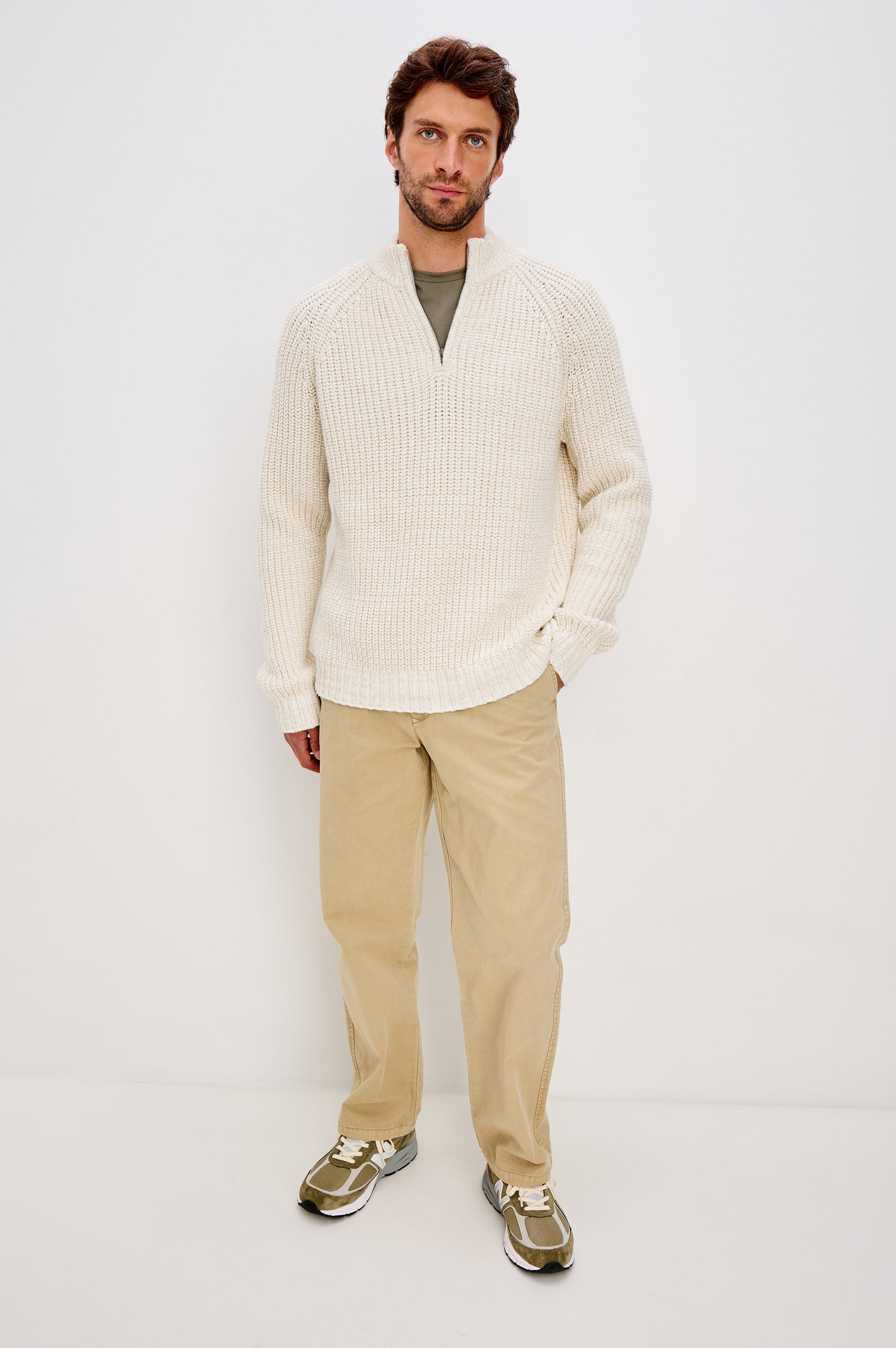 Stratton is a quarter-zip long sleeved sweater knitted from chunky cotton blend knit in Snowdrift Marl colorway. Front full body view featured on model.