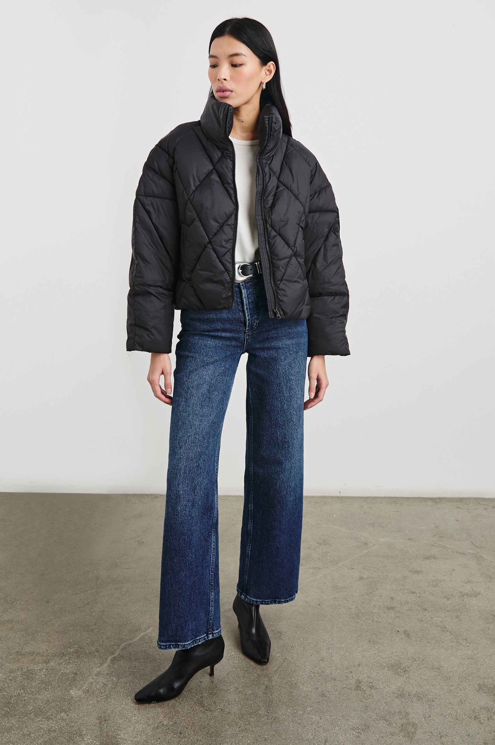 Summit Cropped Puffer Jacket with a Mid-Neck Collar, Two Pockets and a Rails Logo on the Arm in Black Colorway - Front Full Body View Featured on Model