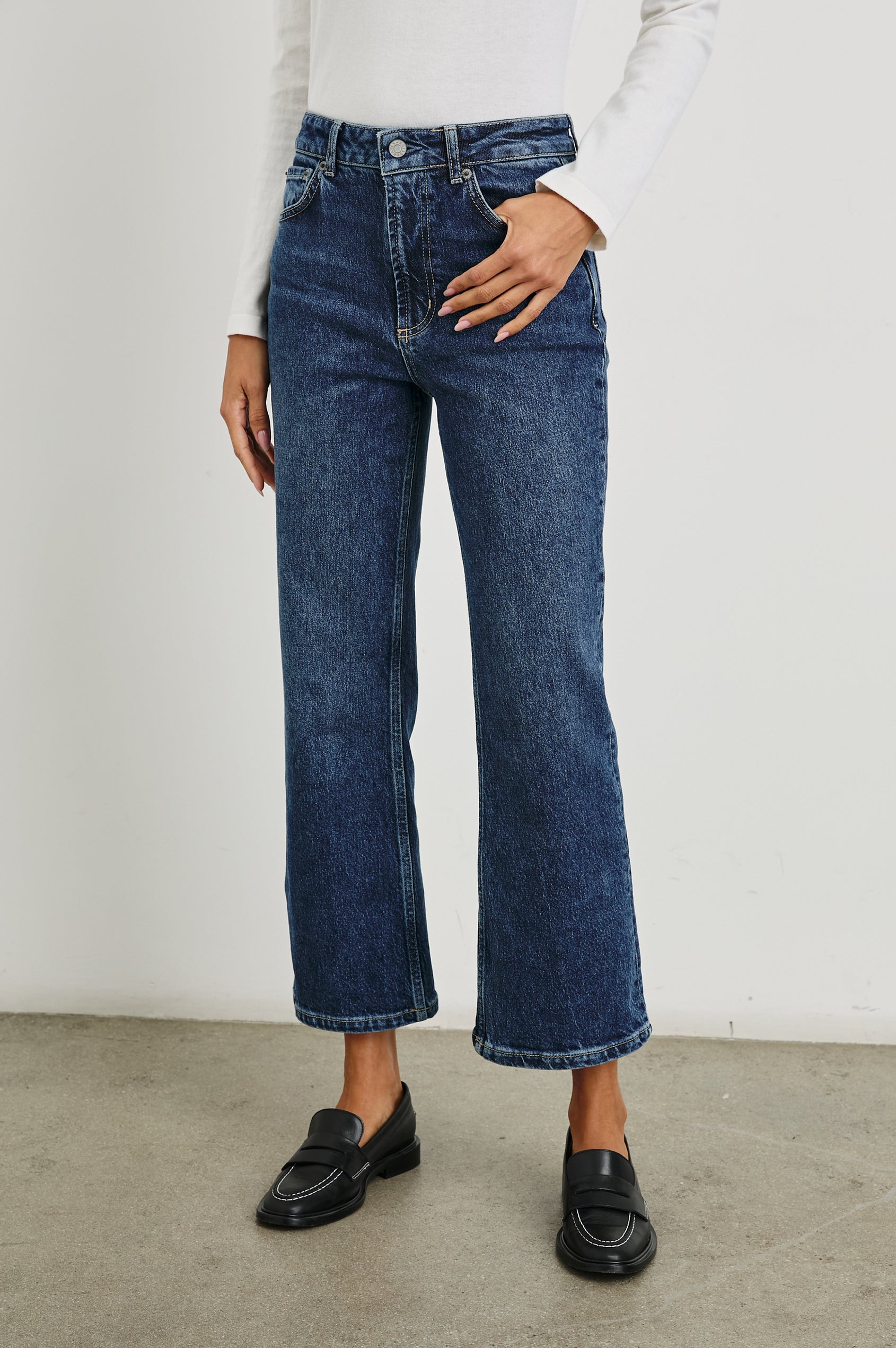 Sunset Crop Slim Fare Jeans with Belt Loops, Two Front Pockets plus a Coin Pocket and Two Back Patch Pockets in Collegiate Blue Colorway - Front View Featured on Model