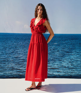 Woman in a red dress standing by the ocean