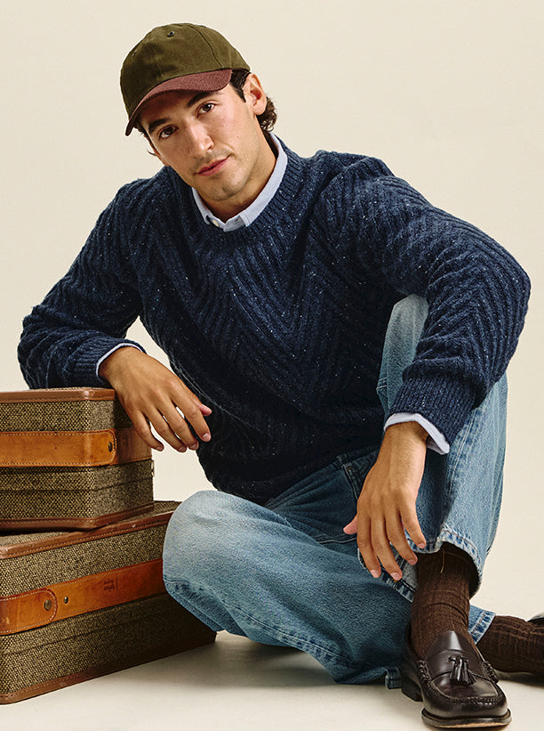 Man wearing a blue sweater with light wash blue jeans