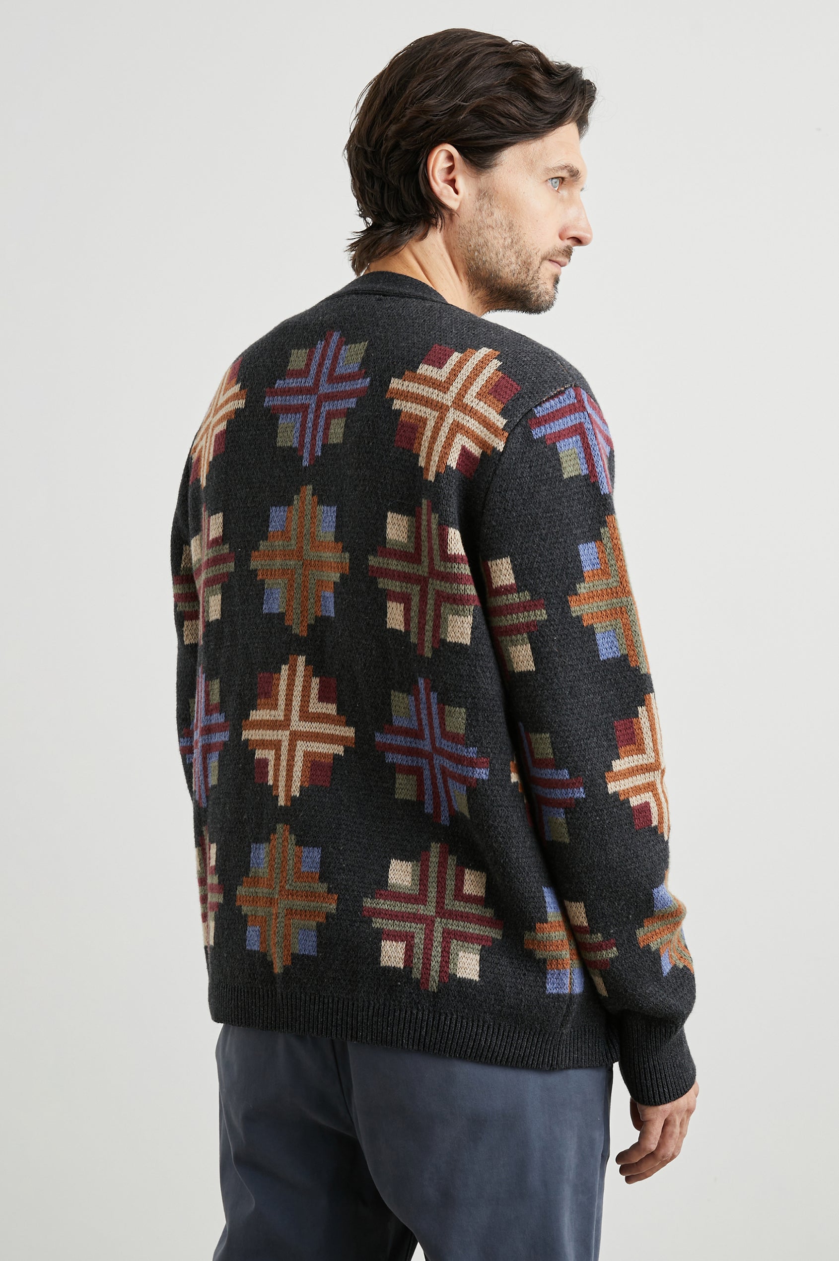 Taos Long-Sleeve Cardigan with Button Closure, V Neck and Ribbed Trim in Heirloom Patchwork Colorway, Multi-Colored Geometric Designs on Dark Grey - Back View Featured on Model