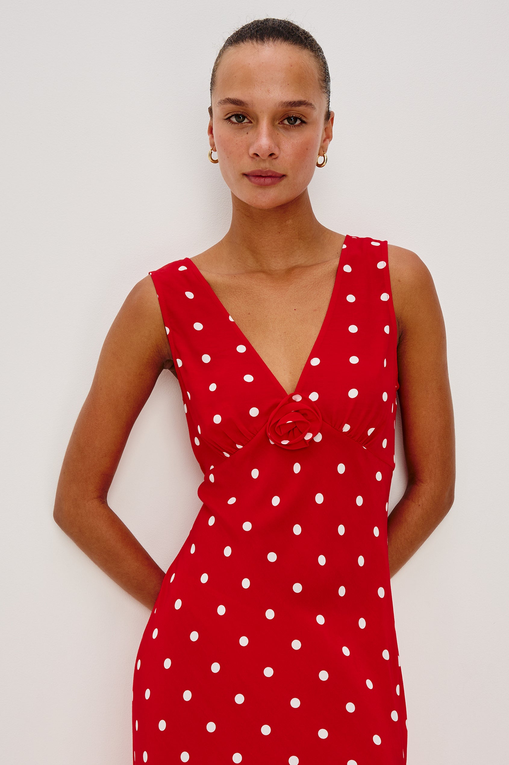 Terena midi dress in Rossa colorway featuring a V neckline, polka dot pattern and fabricated rose at the front chest - front view on model