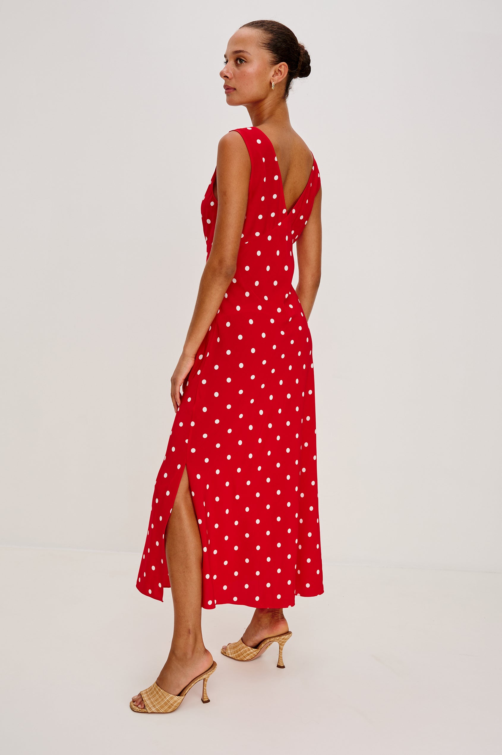 Terena midi dress in Rossa colorway featuring a V neckline, polka dot pattern and fabricated rose at the front chest - back view on model