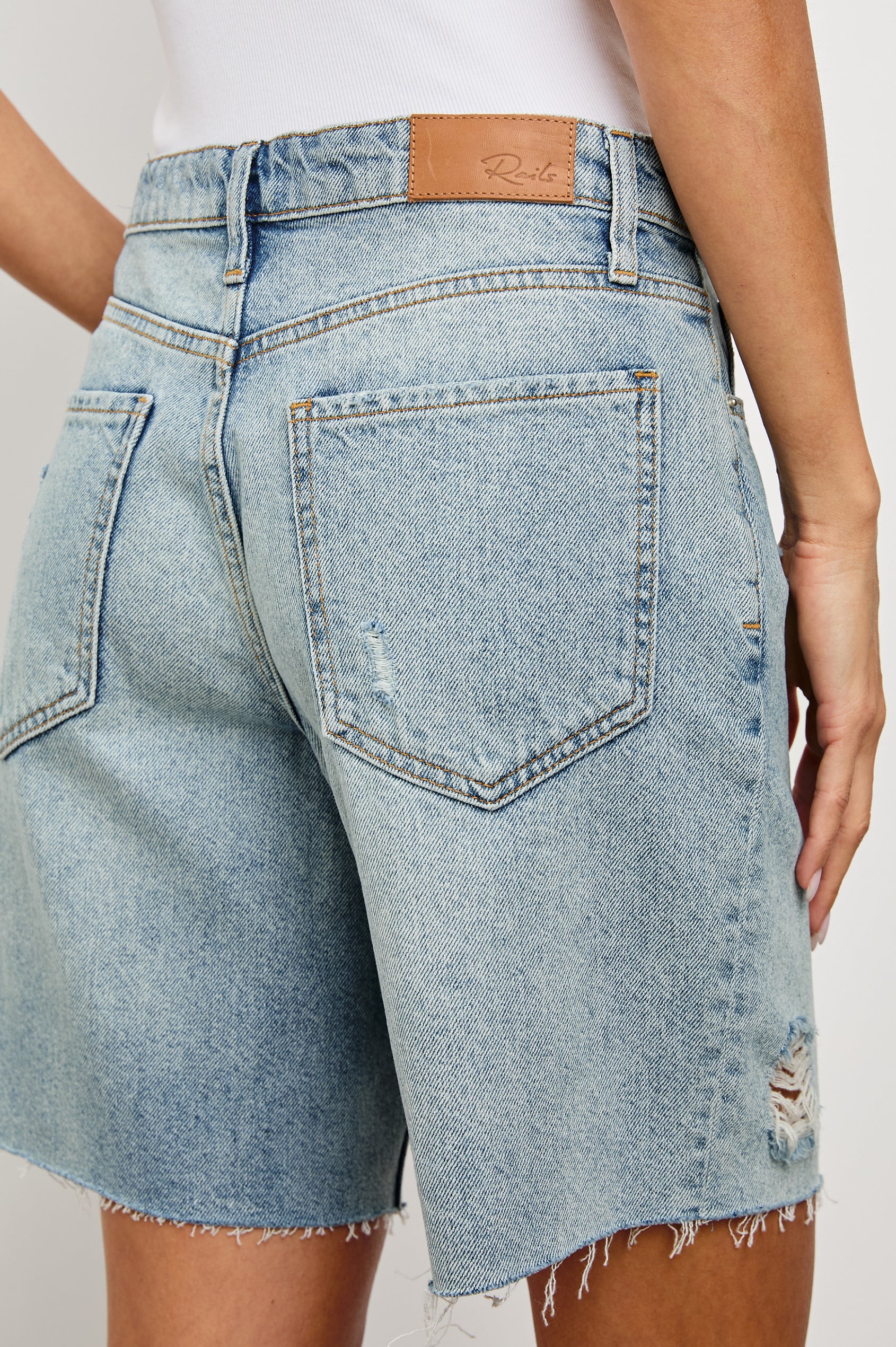 Beachwood high rise bermuda length denim short with distressing details in light wash Light Vintage Distress - close up of back details on model