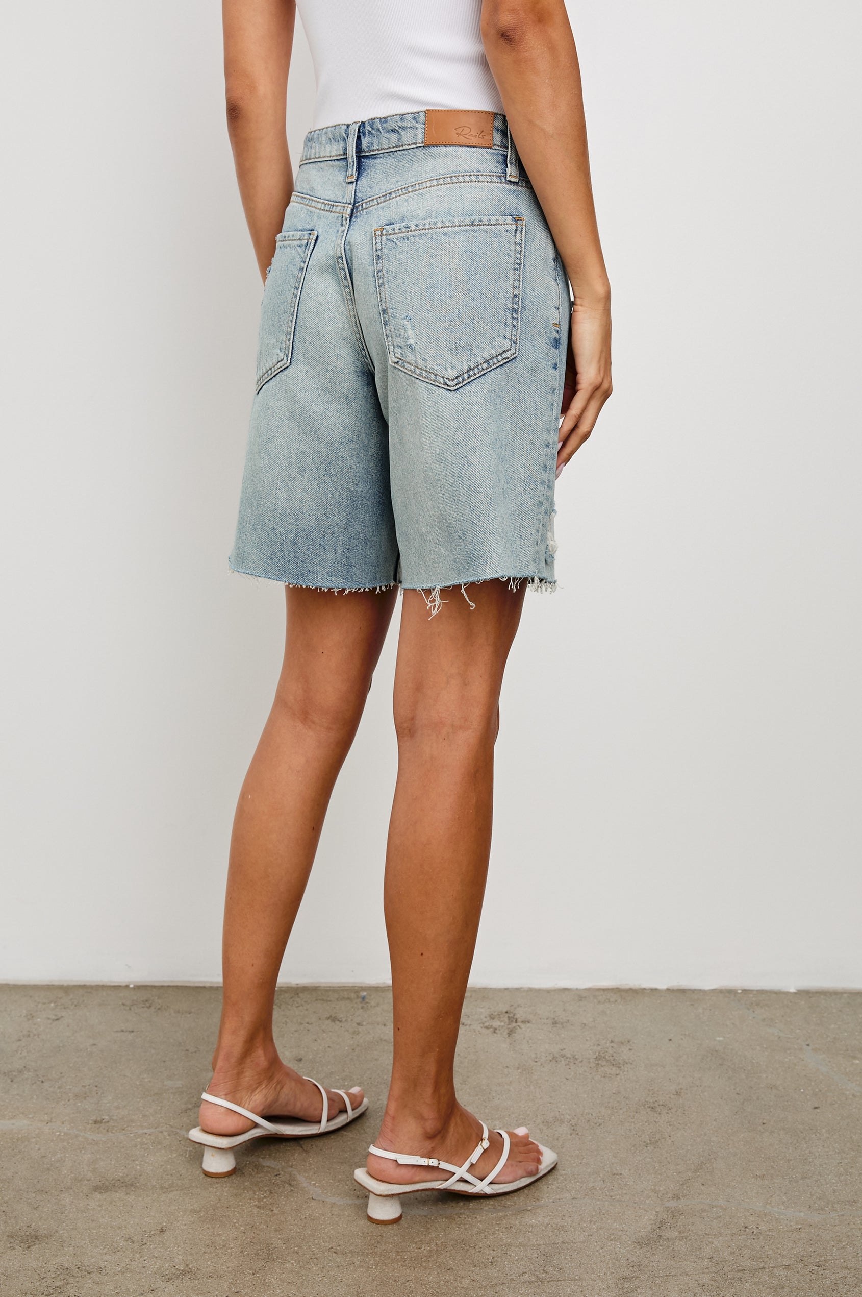 Beachwood high rise bermuda length denim short with distressing details in light wash Light Vintage Distress -back view on model