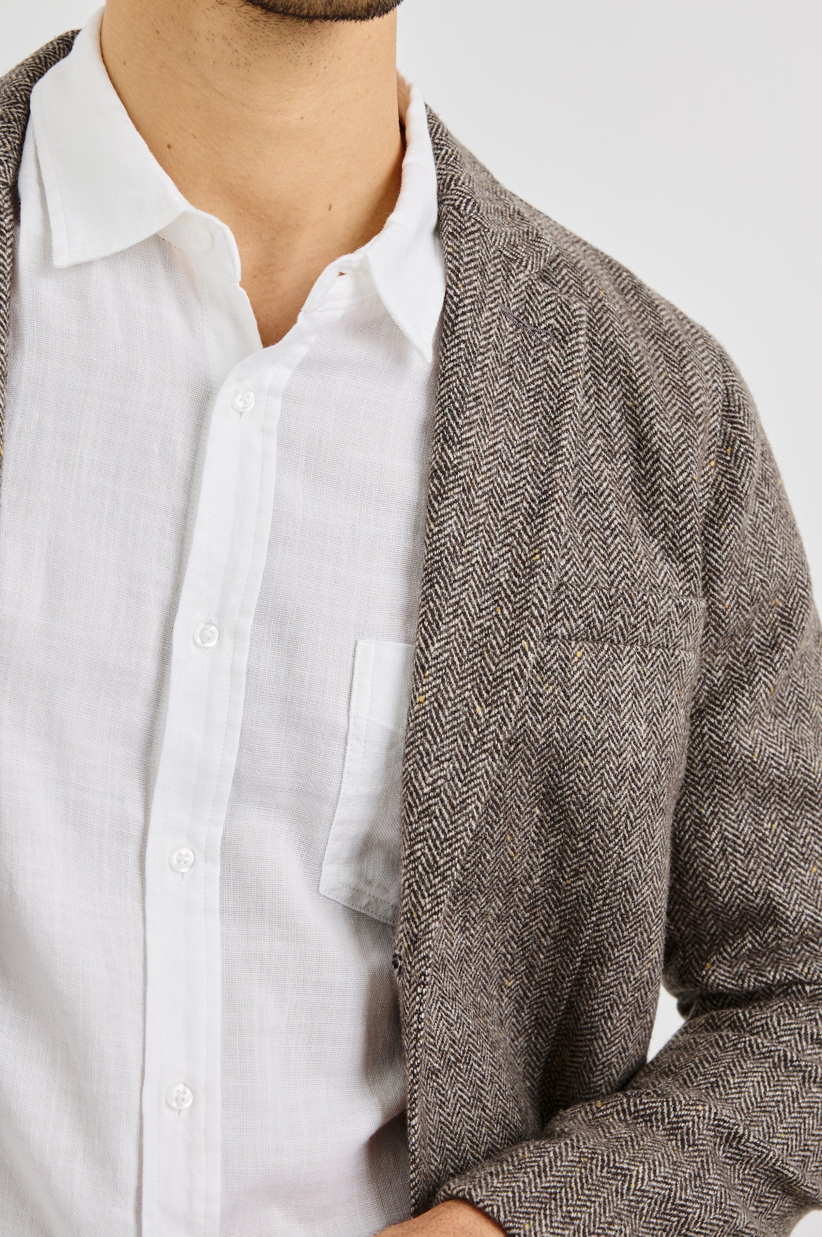 Reynard Blazer with Two Button Closure, Two Front Pockets, a Chest Welt Pocket, Herringbone Fabric in Highland Tweed Colorway, a Brown - Front View Featured on Model