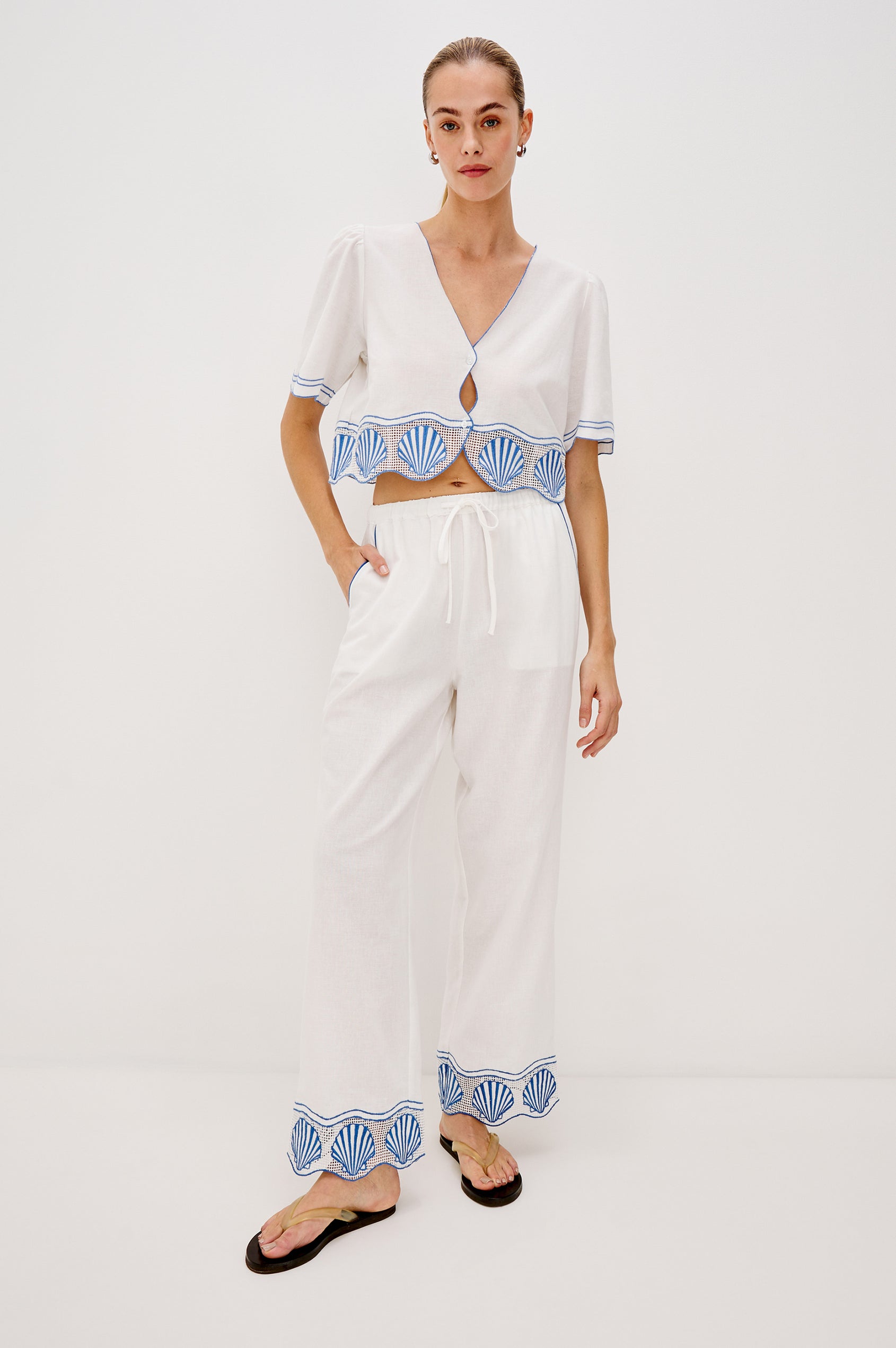 Tildi Drawstring Pant with Side Pockets, Sea Shell Embroidery and Scalloped Hem in White Colorway. Front Full Body View Shown on Model.
