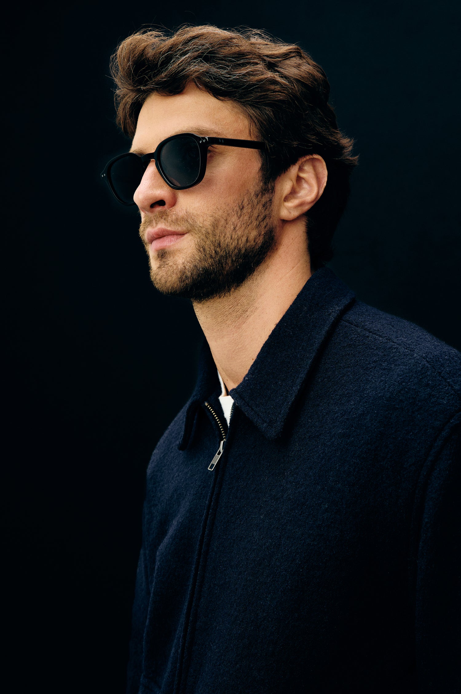 Tilman is a classic collar, front zip jacket, buttoned pockets with top and side entry in Navy Boucle colorway. Side headshot top detail view featured on model.