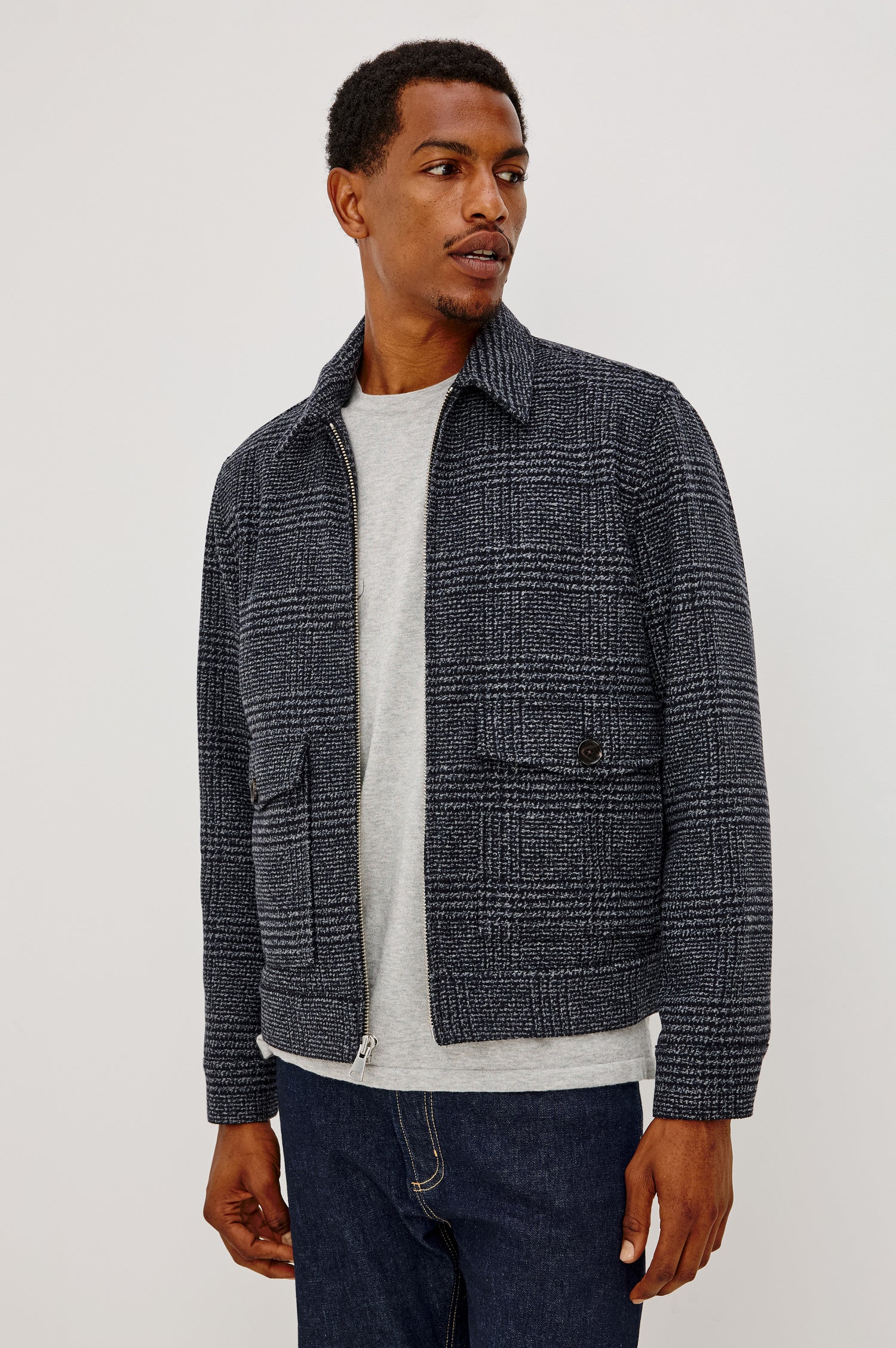 Tillman Jacket in Midweight Textured Wool Blend With Full Custom Lining, Front Zip, Spread Collar, Front Flap Side Entry Pockets, Relaxed FIt, and Long Sleeves in Navy Static Plaid Colorway - Front View Featured on Model.