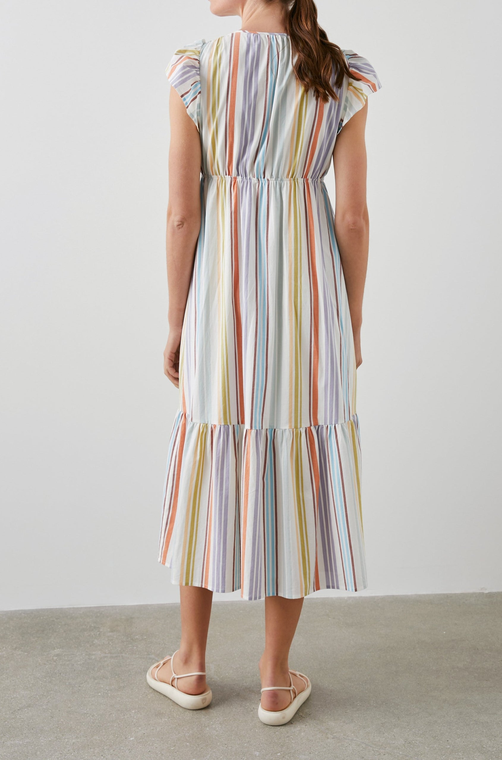 Tina Short Sleeve Midi Dress with Flutter Sleeves, a Deep V Neck with a Cutout and a Tiered Skirt in Oasis Stripe Colorway, Vertical Stripes in Green, Oranges, Purple and Blues on White - Back Full Body View Featured on Model 