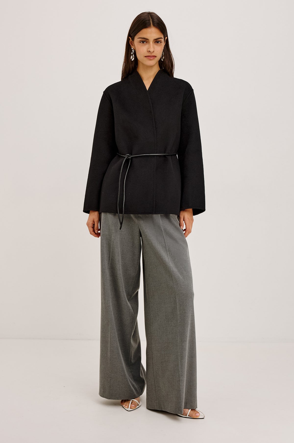Tokyo Jacket in Wool Blend With Collarless Neckline, Leather Belt Ties, Long Sleeves, and Relaxed, Boxy Fit in Black Colorway - Full Body Front View Featured on Model.