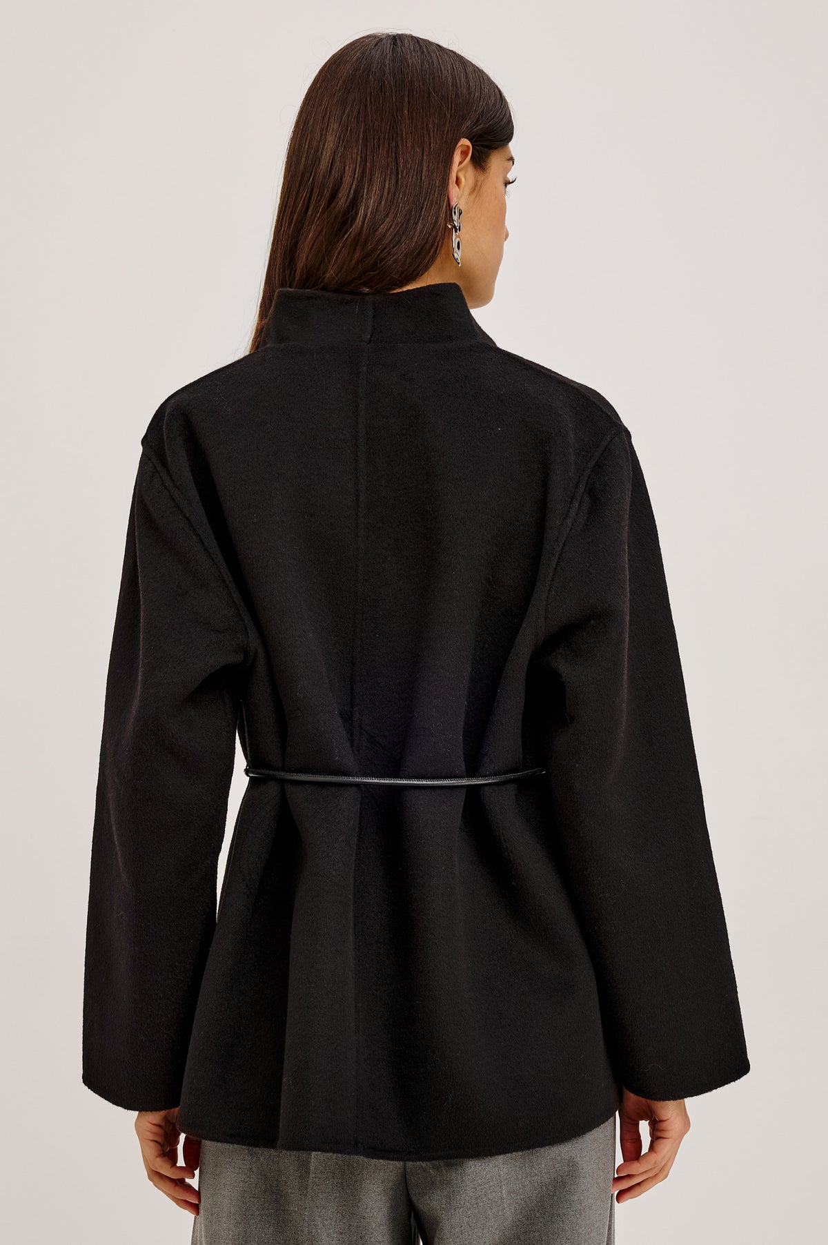 Tokyo Jacket in Wool Blend With Collarless Neckline, Leather Belt Ties, Long Sleeves, and Relaxed, Boxy Fit in Black Colorway - Upper Body Back View Featured on Model.