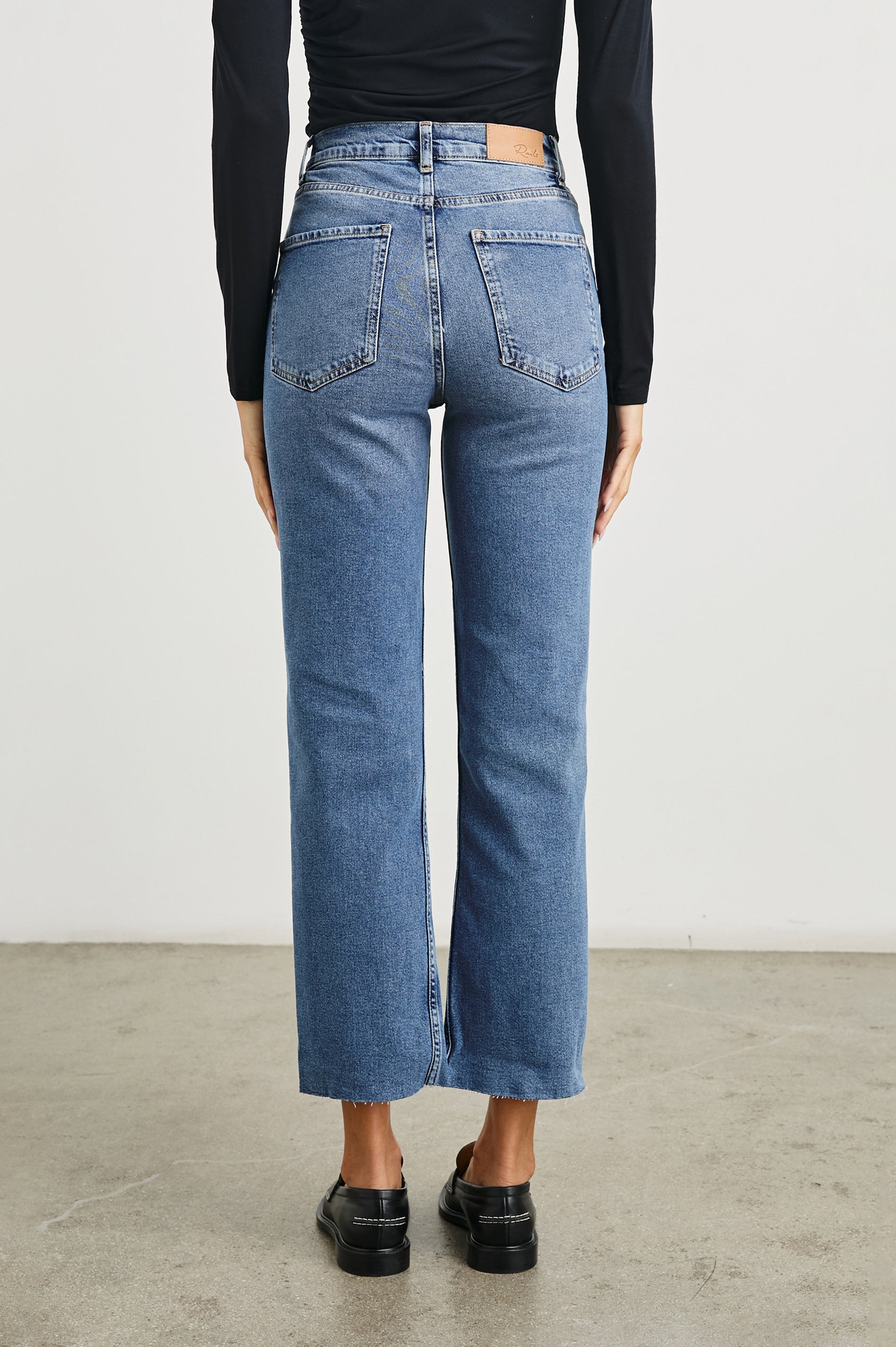 Topanga Crop Straight Jeans with an Asymmetrical Crop, Belt Loops, Two Front Pockets plus a Coin Pocket and Two Back Patch Pockets in Pure Indigo Colorway - Back View Featured on Model