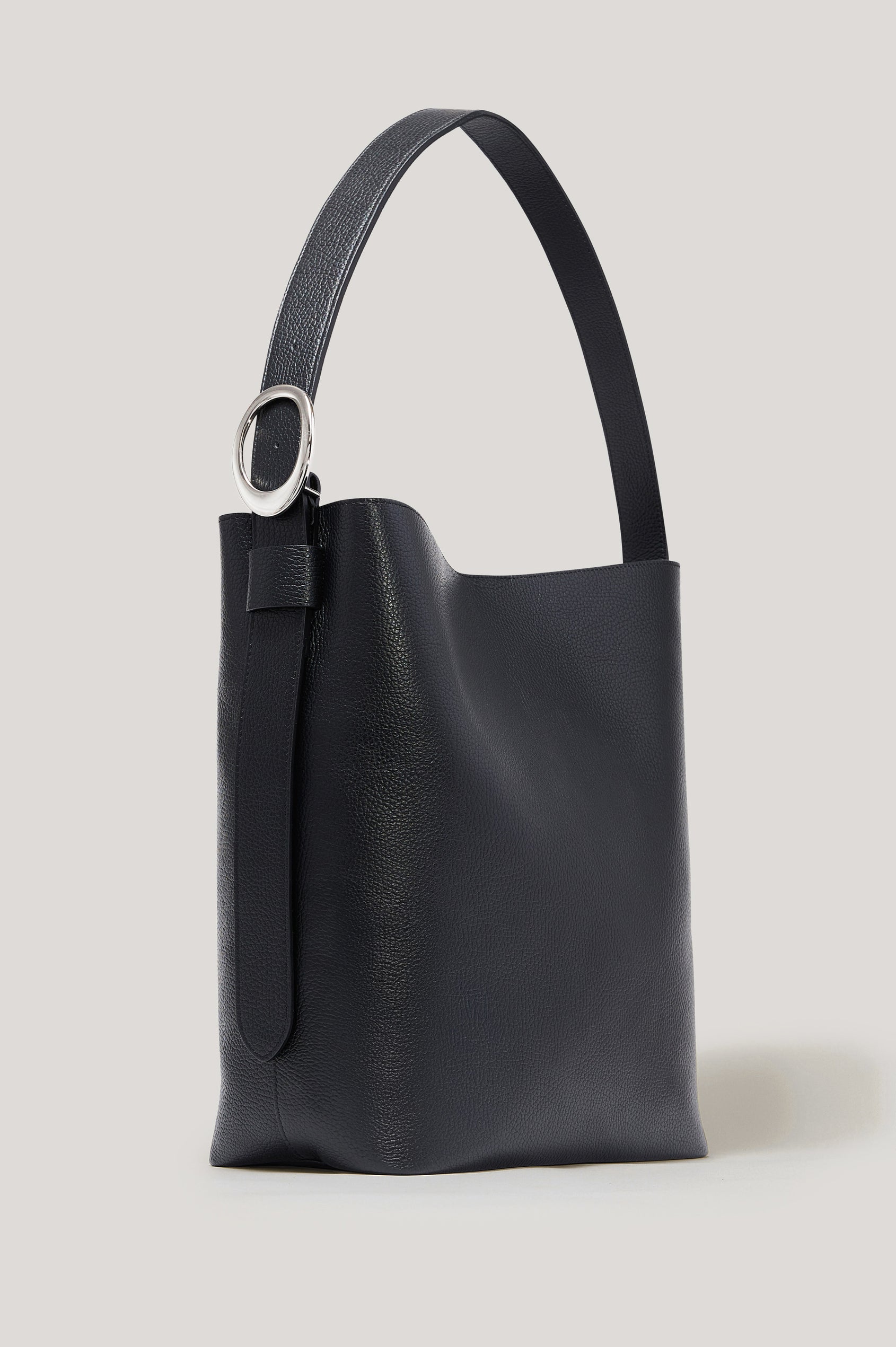 Torino Bucket Bag in Italian Pebbled Leather With Adjustable Strap and Polished Silver Oval Buckle, Microsuede Lining, Interior Magnetic Closure, Snap Button-Slip Pocket, and Subtle Branded Detailing in Black Colorway - Front View Featured