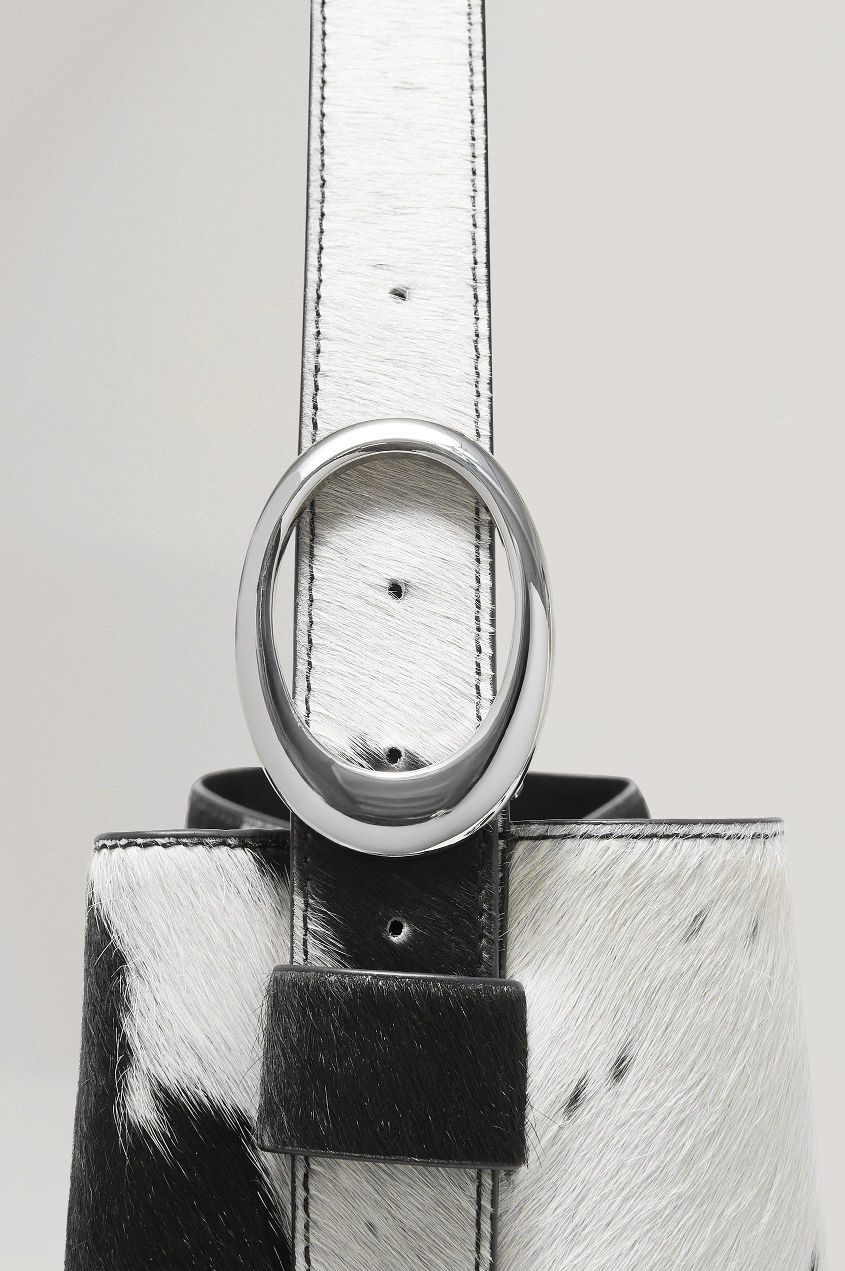 Torino Bucket Bag in Cow Print Haircalf With Adjustable Strap and Polished Silver Oval Buckle, Microsuede Lining, Interior Magnetic Closure, Snap Button-Slip Pocket, and Subtle Branded Detailing in Cowgirl Haircalf Colorway Colorway - Front View Featured