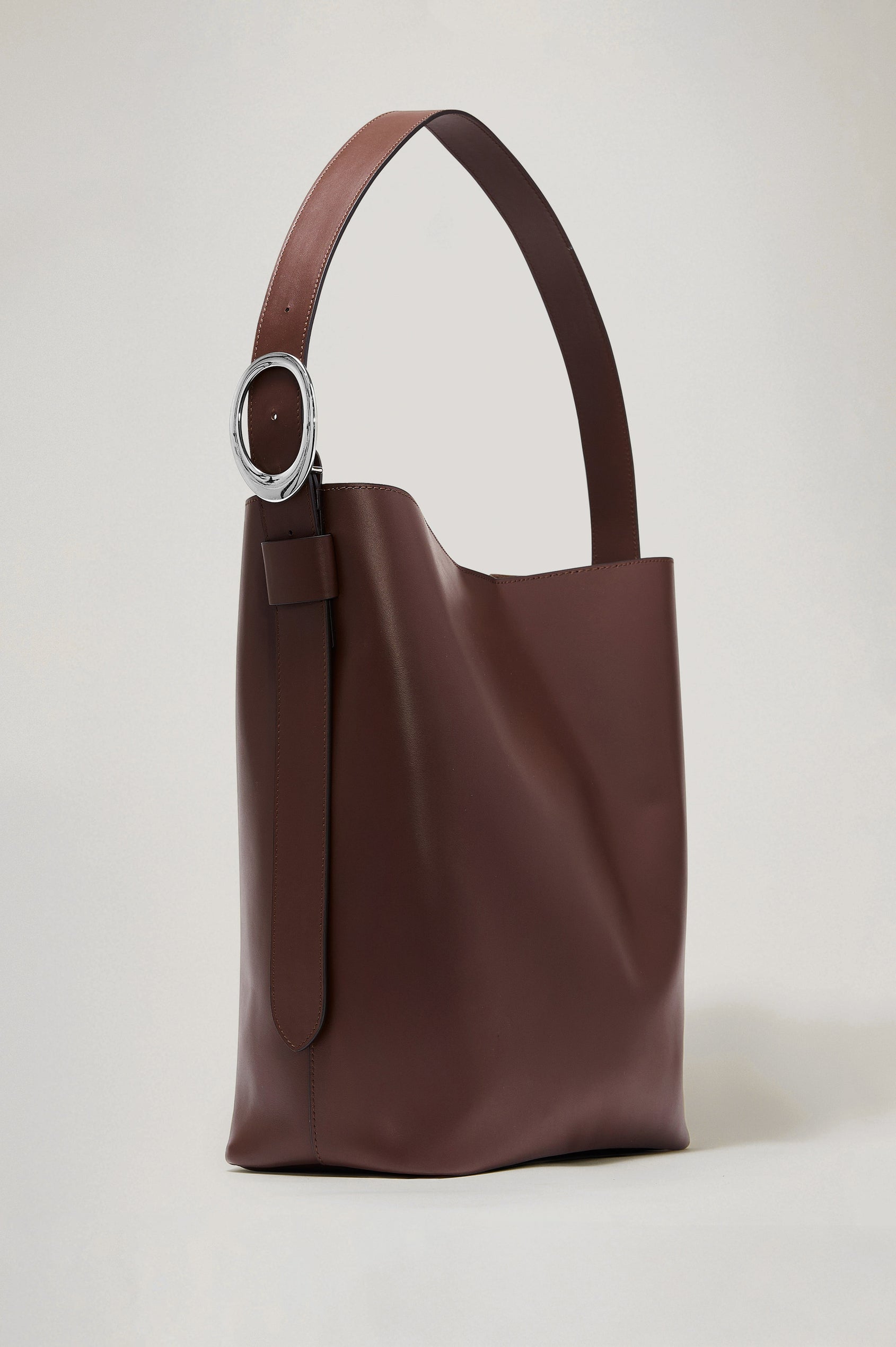 Torino Bucket Bag in Italian Leather With Adjustable Strap and Polished Silver Oval Buckle, Microsuede Lining, Interior Magnetic Closure, Snap Button-Slip Pocket, and Subtle Branded Detailing in Cowgirl Haircalf Colorway Colorway - Front View Featured