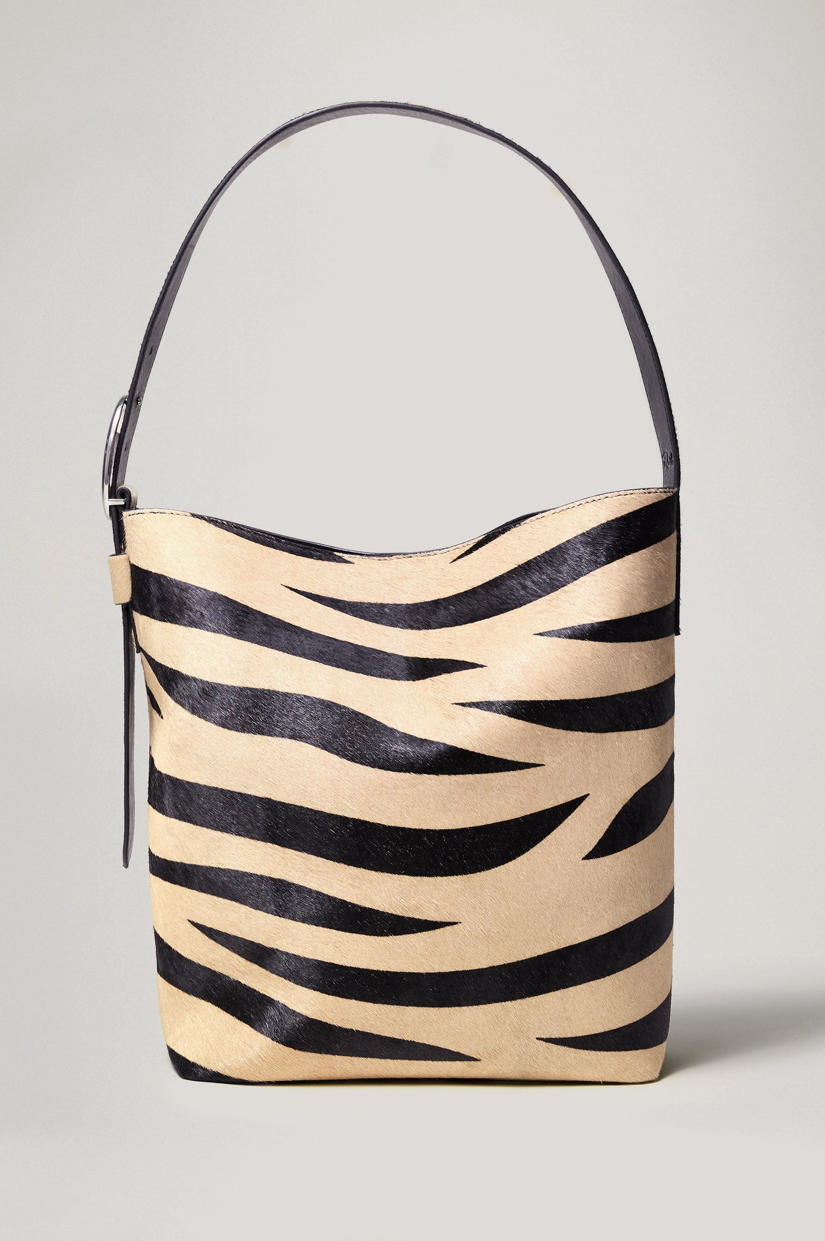 Torino Bucket Bag in Zebra Print Haircalf With Adjustable Strap and Polished Silver Oval Buckle, Microsuede Lining, Interior Magnetic Closure, Snap Button-Slip Pocket, and Subtle Branded Detailing in Zebra Haircalf Colorway - Front View Featured