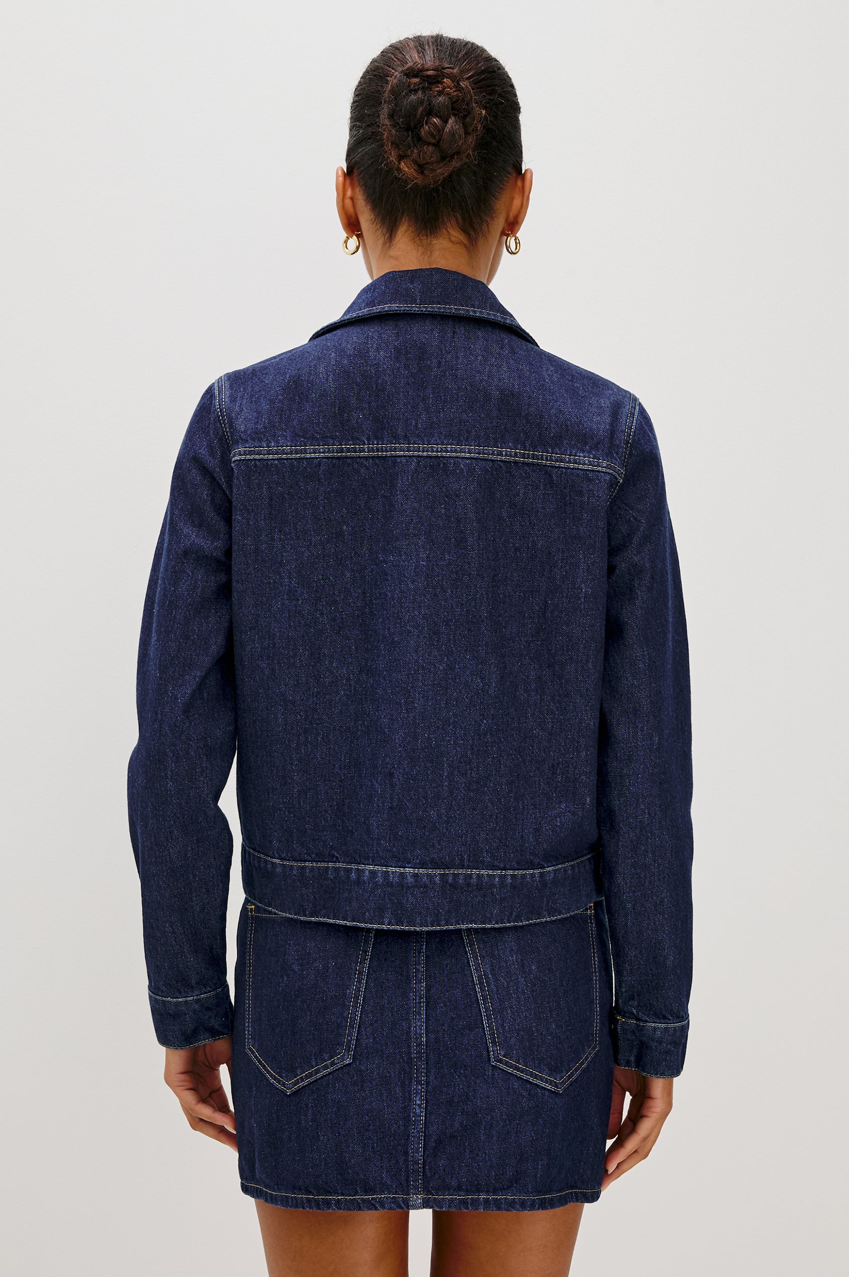 The Trabuco is a collared two-way zip front jacket with two chest pockets and a western style yoke in Deep Indigo colorway - a rinse denim wash. Back view featured on model.