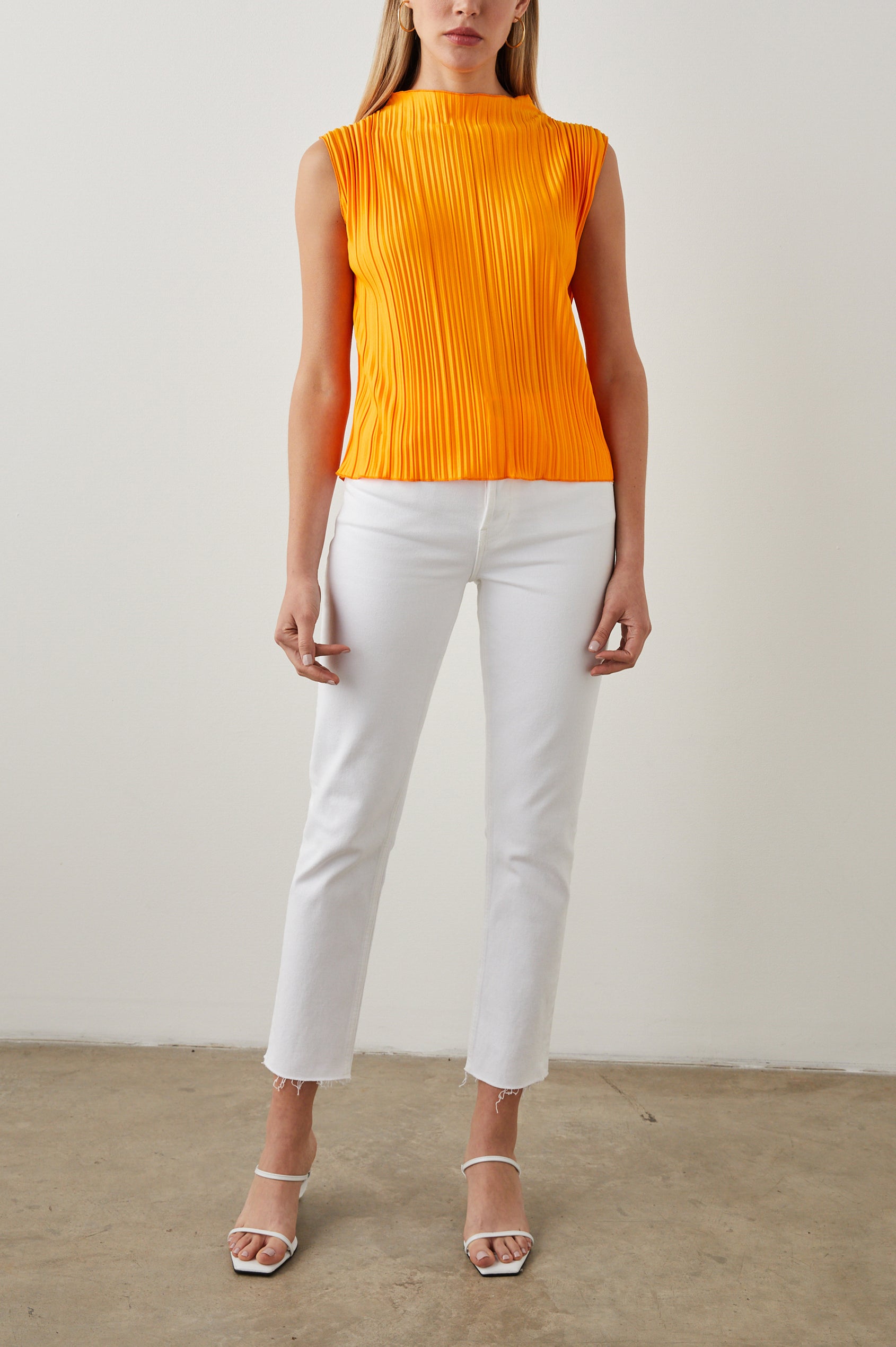 Trea Sleeveless Top with a Mock Neck and Pleated Texture in Marigold Colorway - Front Full Body View Featured on Model