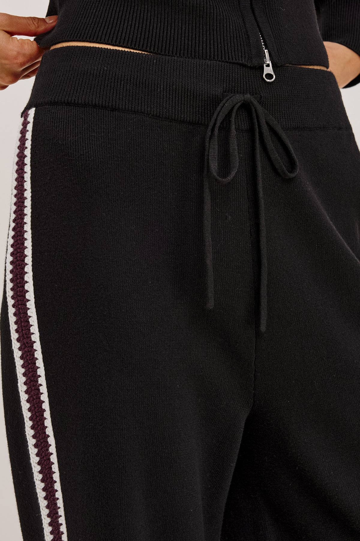 Tucker Pant in Soft Structured Knit With Wide Straight Legs, Drawstring Waist Ties, and Crochet Side Stripes in Black Merlot Stripe - Upper Body Front Detail View Featured on Model.