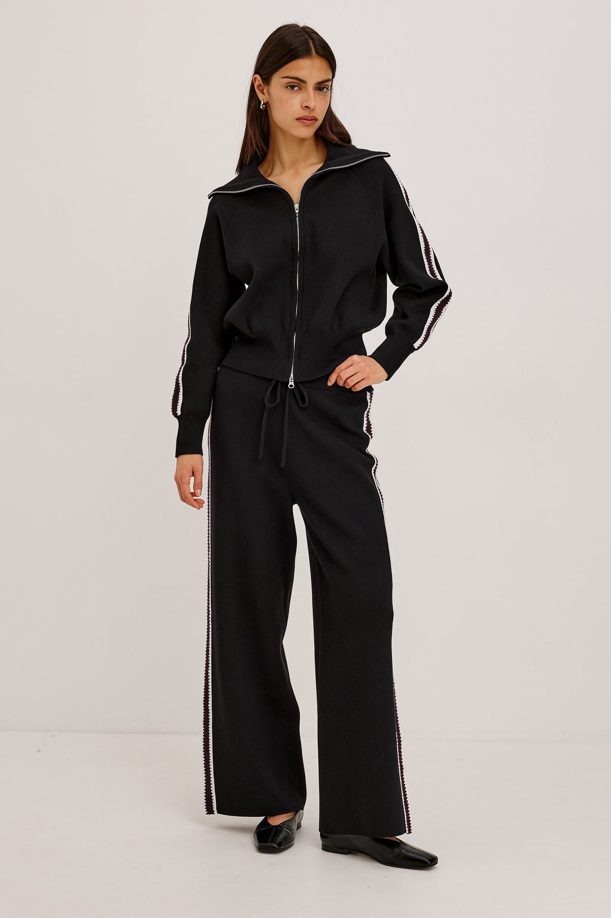Tucker Pant in Soft Structured Knit With Wide Straight Legs, Drawstring Waist Ties, and Crochet Side Stripes in Black Merlot Stripe - Full Body Front View Featured on Model.