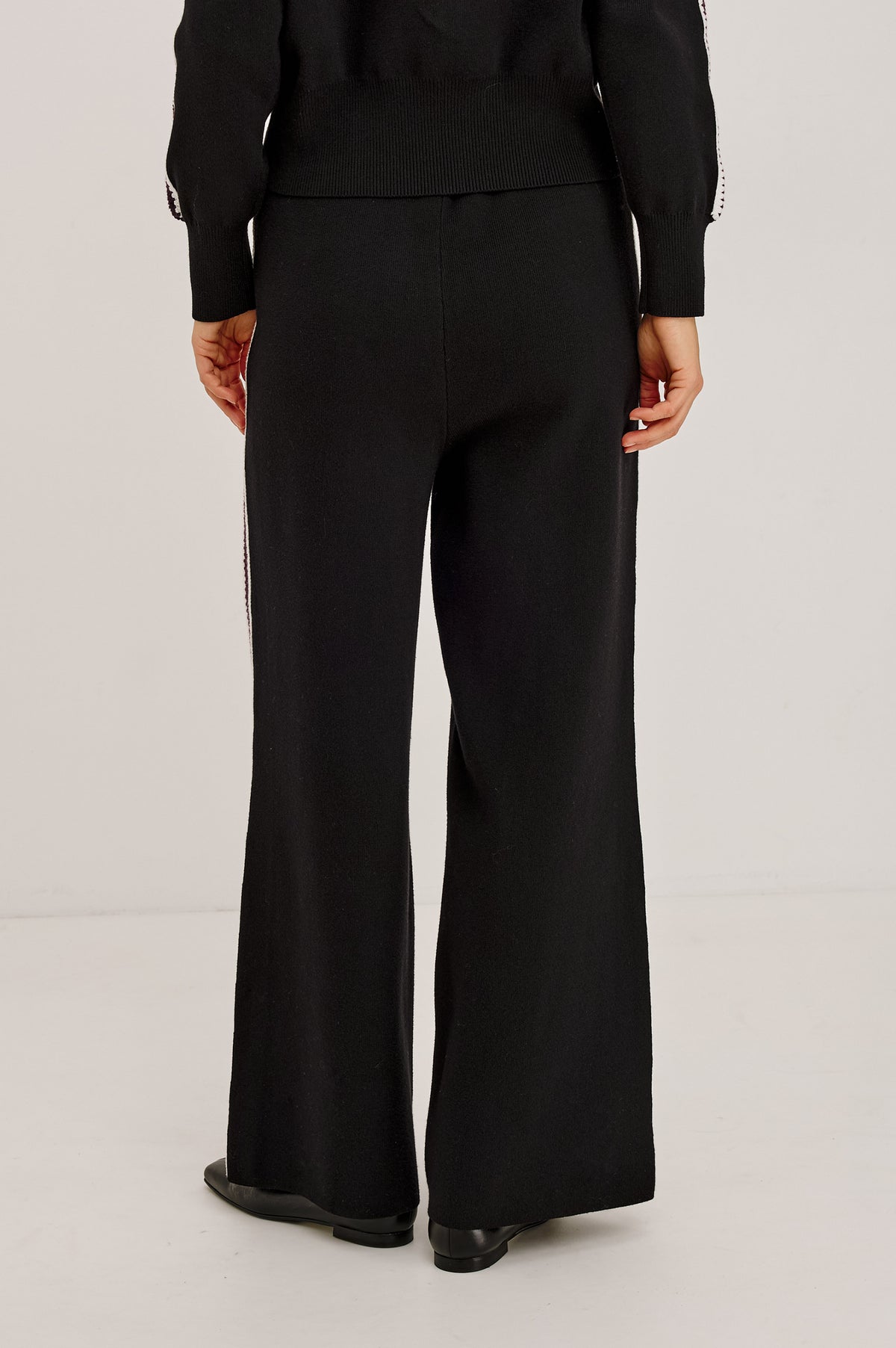 Tucker Pant in Soft Structured Knit With Wide Straight Legs, Drawstring Waist Ties, and Crochet Side Stripes in Black Merlot Stripe - Upper Body Back View Featured on Model.
