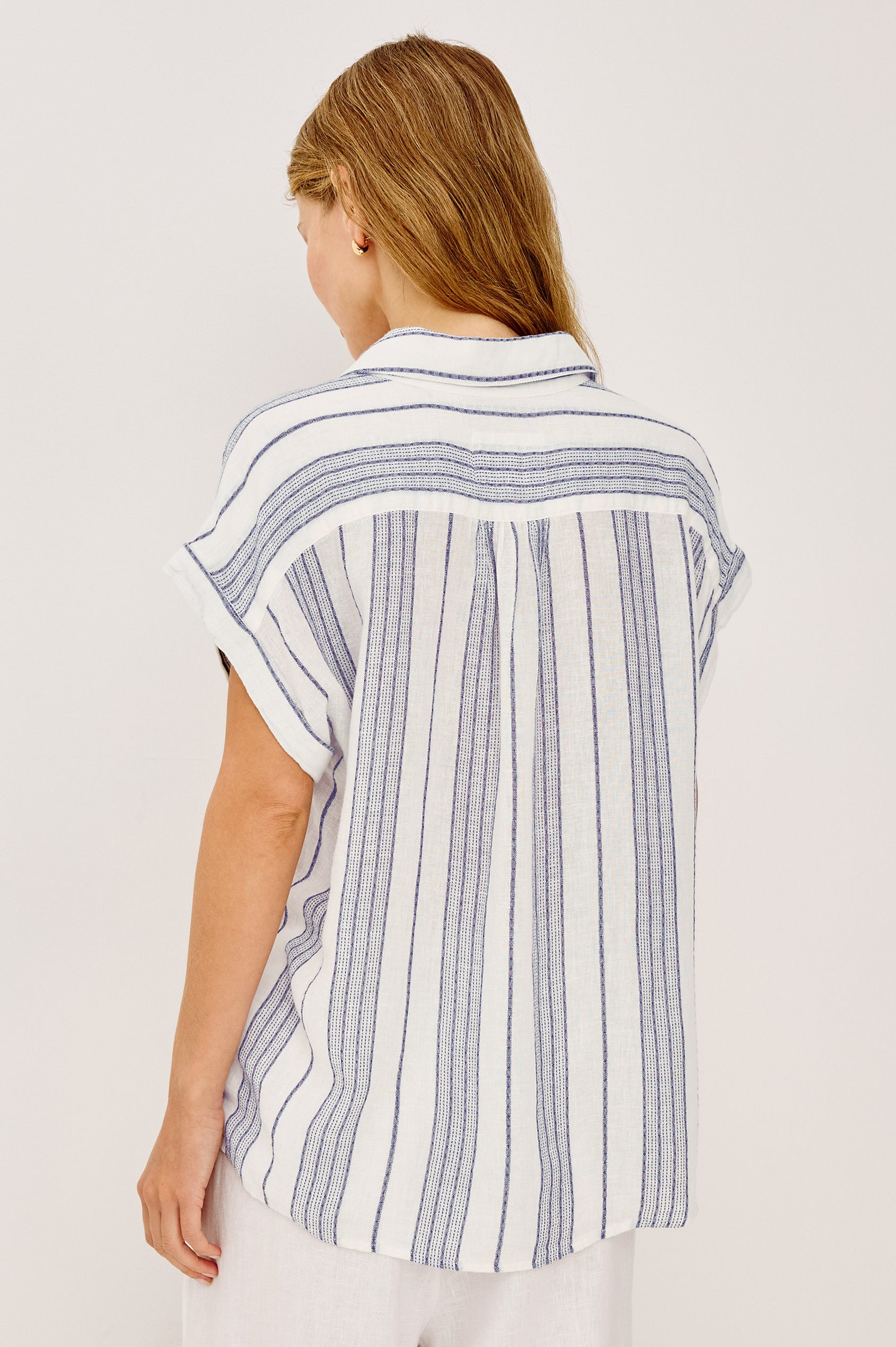 Tuscany Shirt in Linen Blend With Collar, Front Half Placket, Capped Cuff Sleeves, and Slightly-Boxy Fit Fit in Washed Blue Colorway - Upper Body Back View Featured on Model