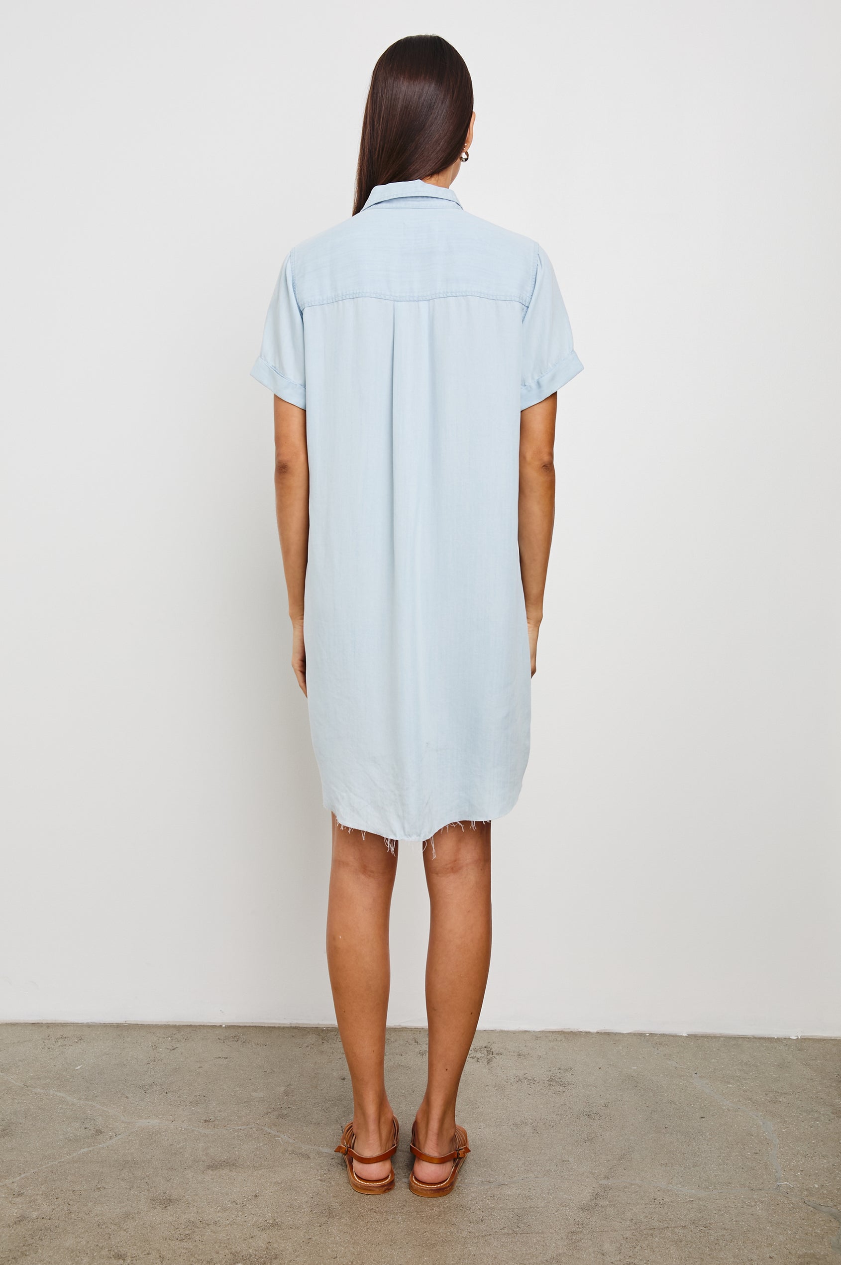 Valerie Short-Sleeve Denim Mini Dress with Rolled Cuffs, a Collar, a Half Sealed Placket, a Chest Pocket and a Raw Hem in Light Vintage Colorway - Back Full Body View Featured on Model 