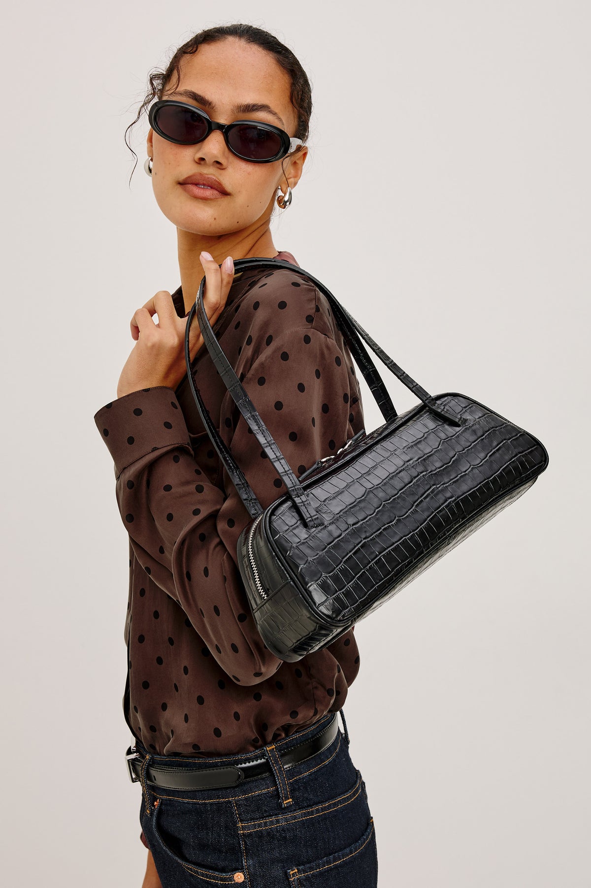 Varese Baguette Bag in Black Croc Embossed Leather With Top Straps, Top-Zip Closure, and Interior Slip Pocket - Front Product View Featured on Model