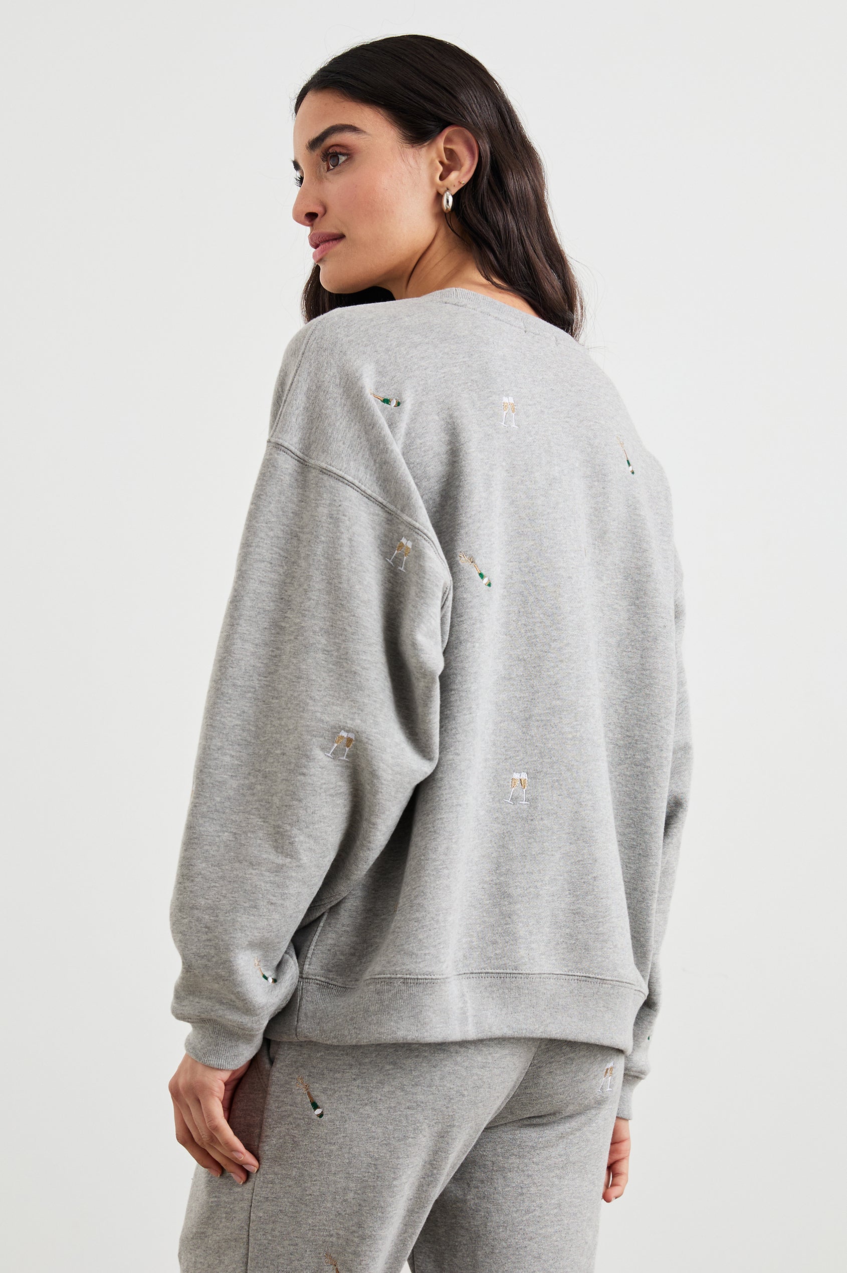 The Varsity Sweatshirt with a Crew Neck and embroidered Champagne Glasses in Champagne Embroidery Colorway, on light grey - Back View Featured on Model 