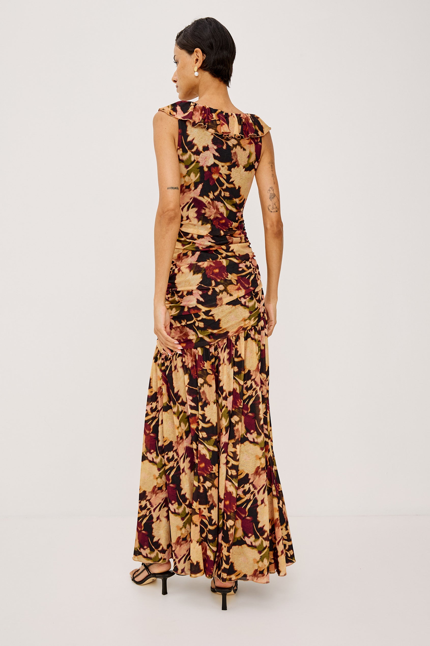Veda Maxi Dress in Self-Lined Mesh With Sleeveless Cut, Full Lining, Ruffle V-Neckline, Ruched Bodice, and A-Line Skirt in Dark Flora Colorway - Full Body Back View Featured on Model