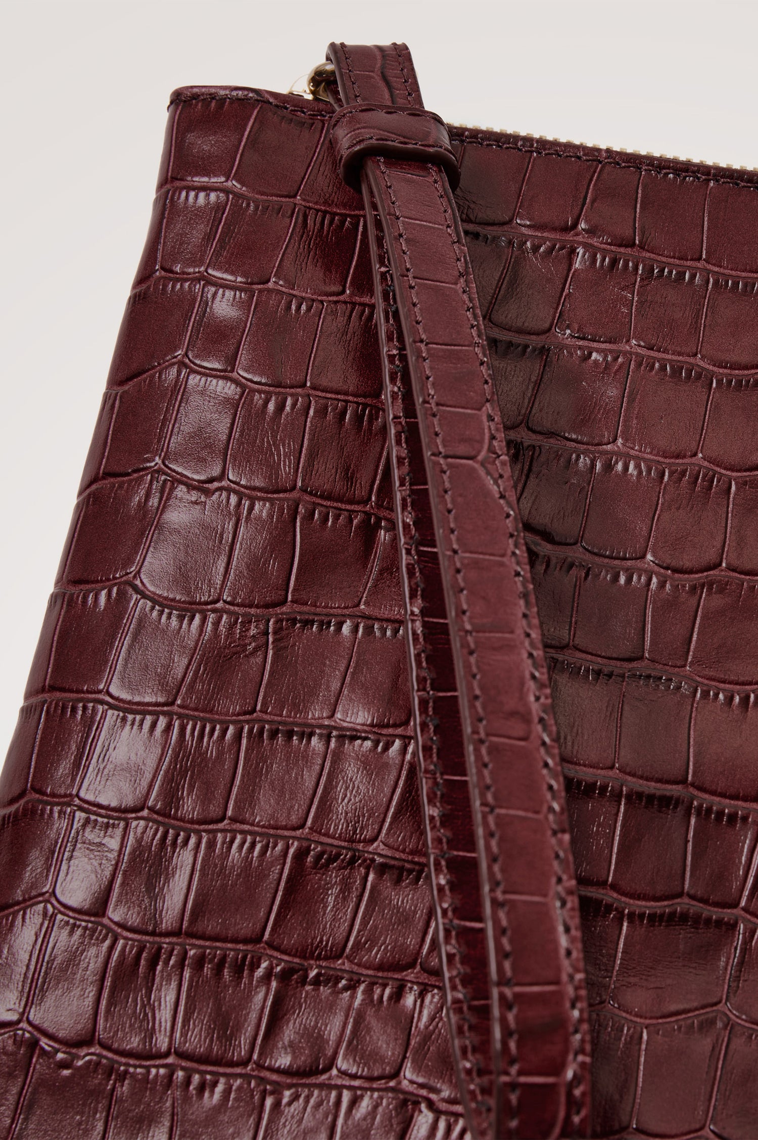 Verona Clutch Bag in Croc-Embossed Leather With Attached Wristlet Strap, Top Zip Closure, and Interior Slip Pocket in Burgundy Croc Embossed Colorway - Close Up Product View Featured